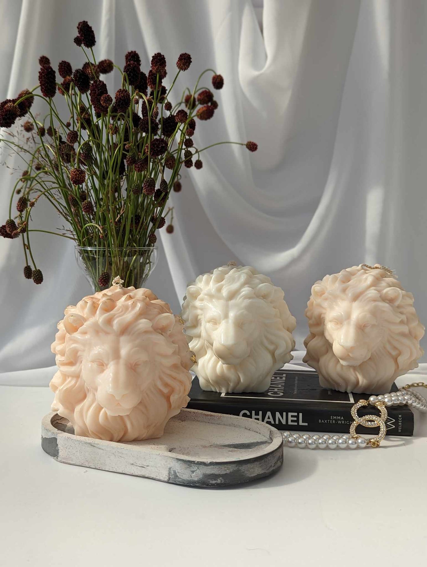 Picture of 3 lion's head candle in different shades of beige, peach and cream