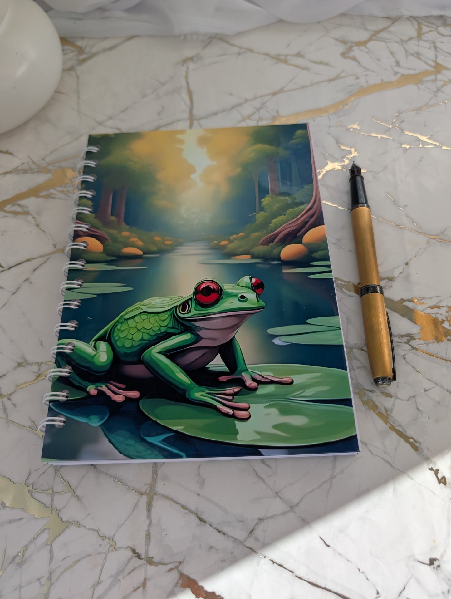 Frog Gift - Top view of a handmade, glossy hardback cover notebook, featuring a colourful frog on a lilypad design