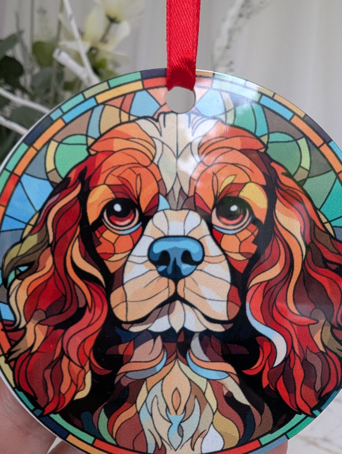 Close up of Cavalier King Charles hanging ornament featuring a stunning stained glass style design in blues.