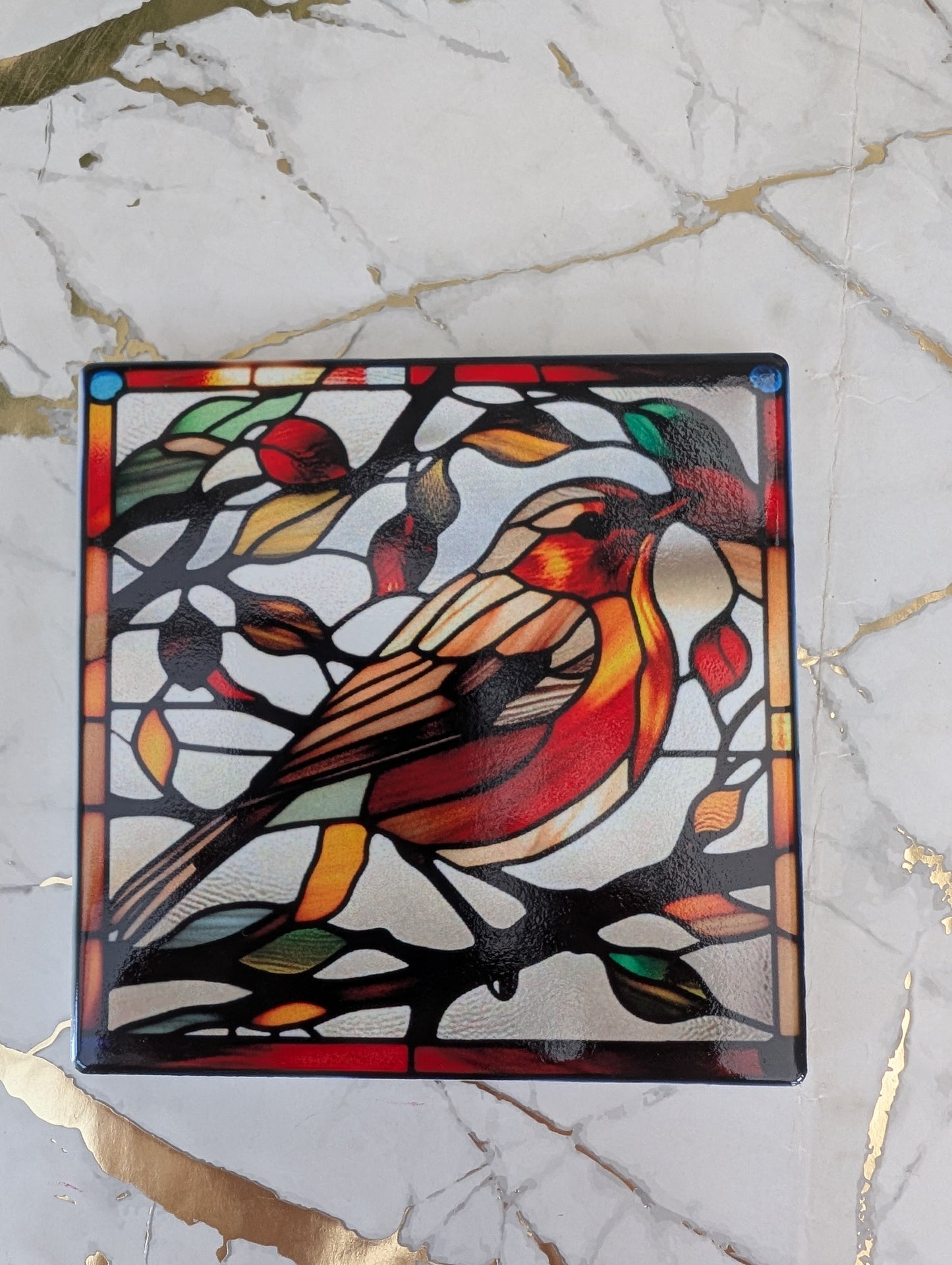 Close up of square ceramic stained glass style Robin Coaster