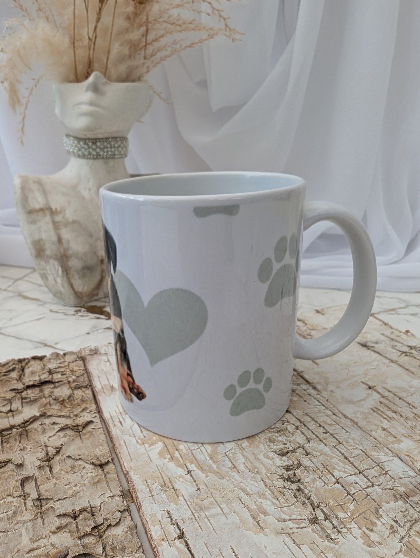 Right side view of white Rottweiler mug with paw prints on a wooden surface