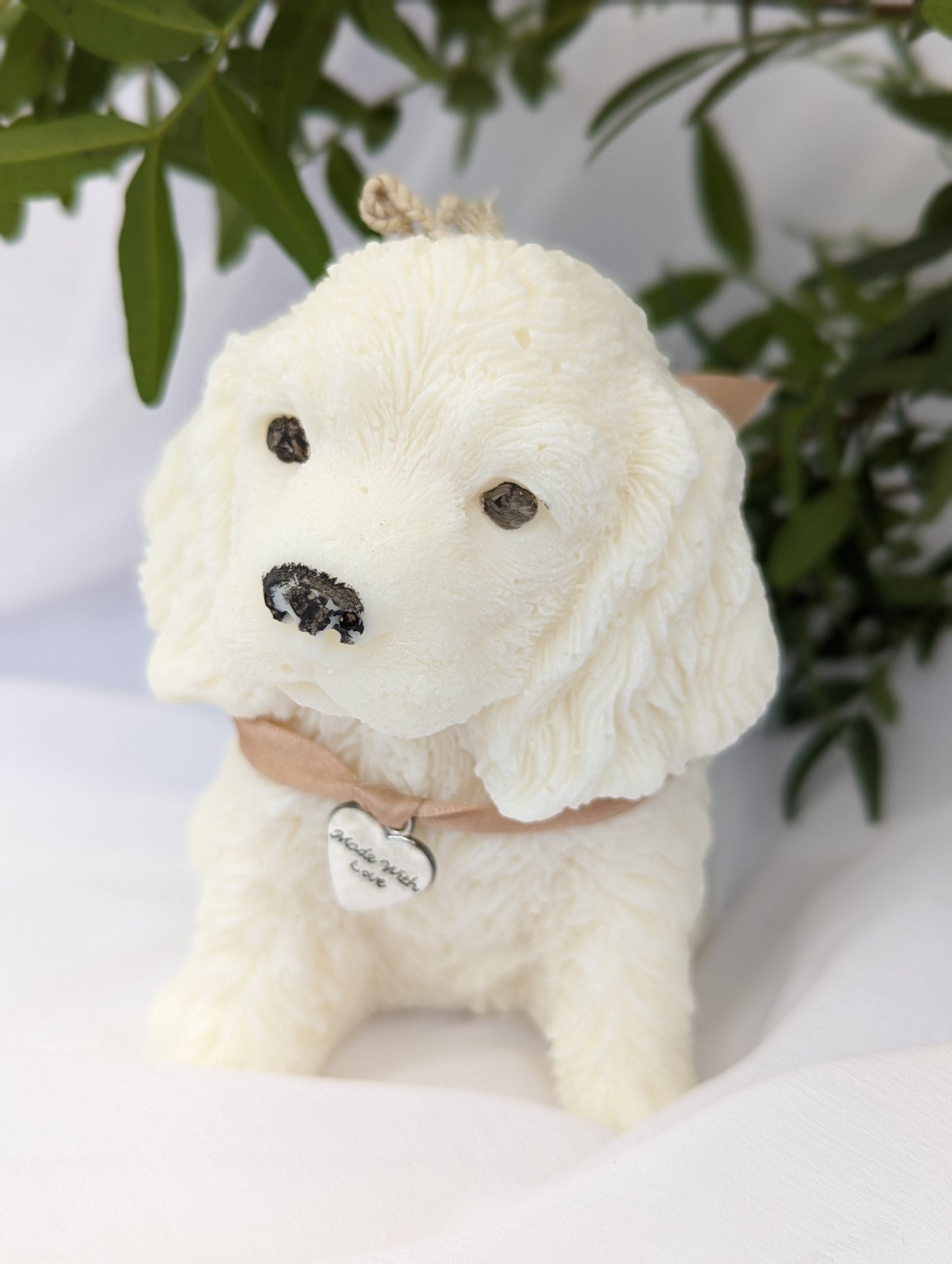 White moulded Cocker Spaniel puppy candle with ribbon and charm detail around the neck