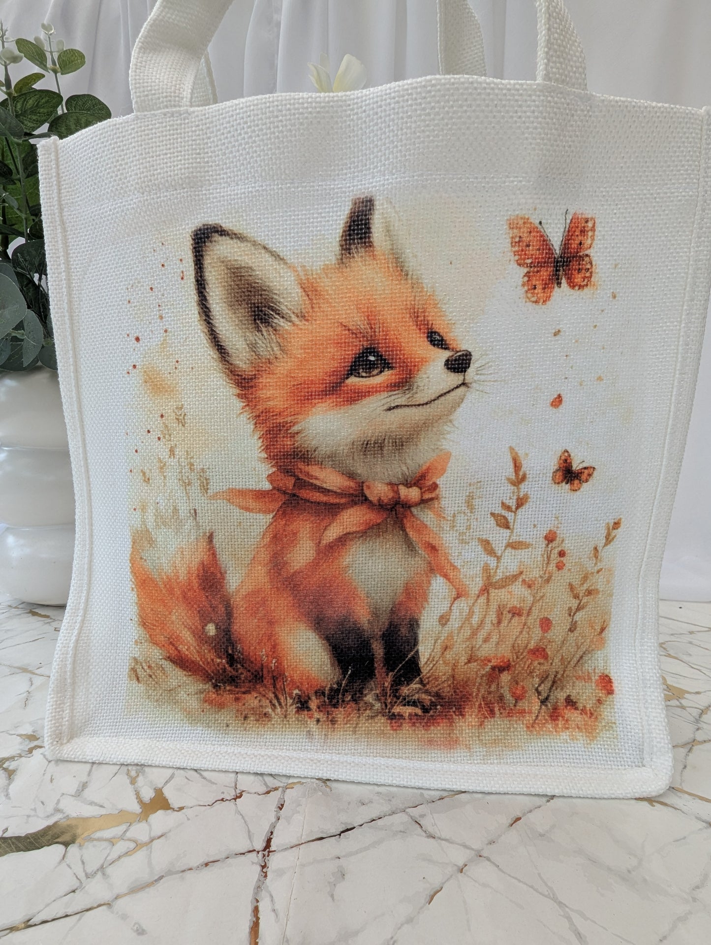 Fox Tote bag seen in close up - with a cute fox and butterfly design on a marble surface