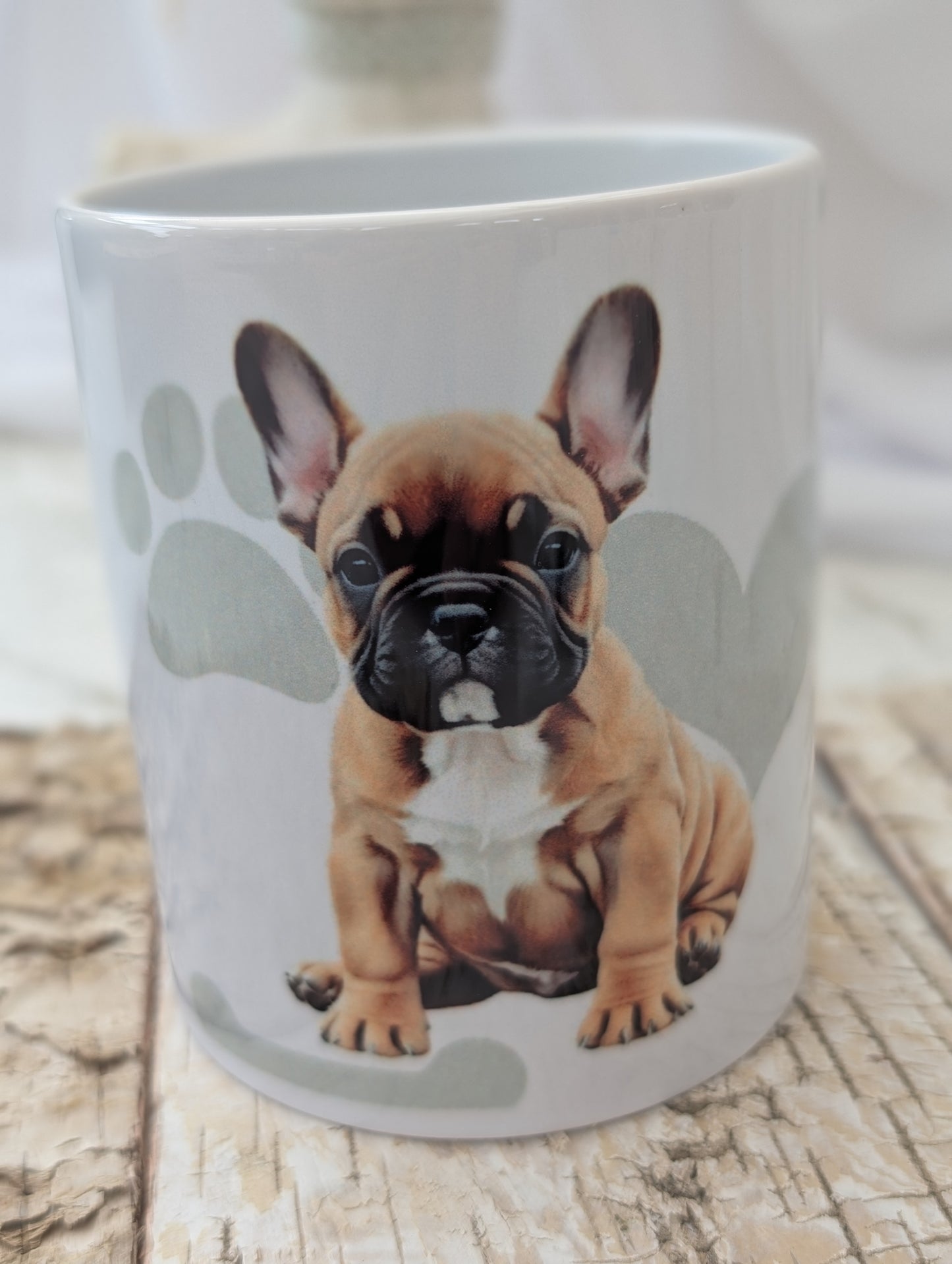 Close up of ceramic Dog mug with fabulous watercolour image of tan and white French Bulldog against a background of soft grey colour hearts, bones and pawprints.