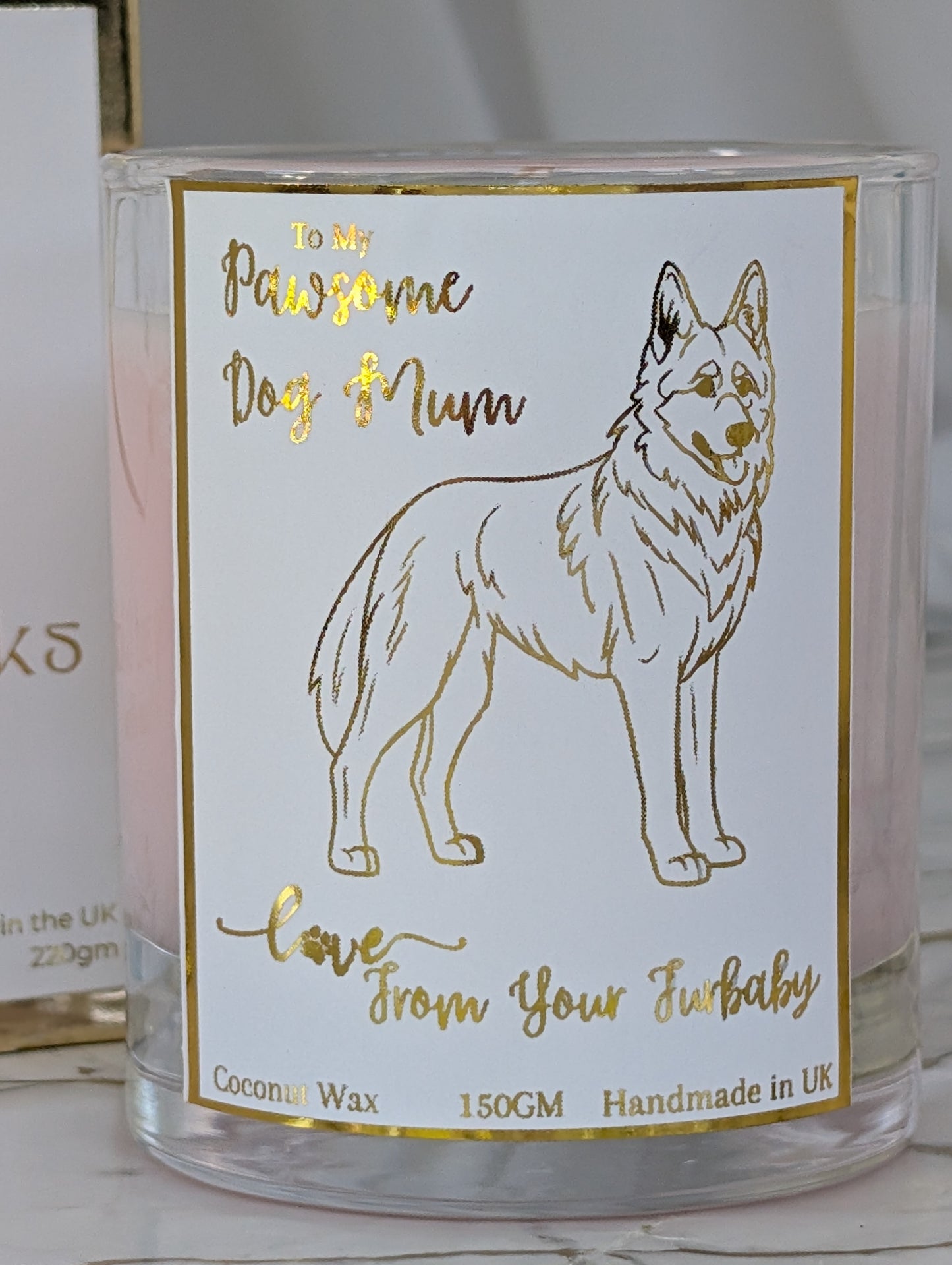 Close up of German Shepherd dog mum candle in clear glass container with gold foiled label featuring image of German Shepherd Dog.