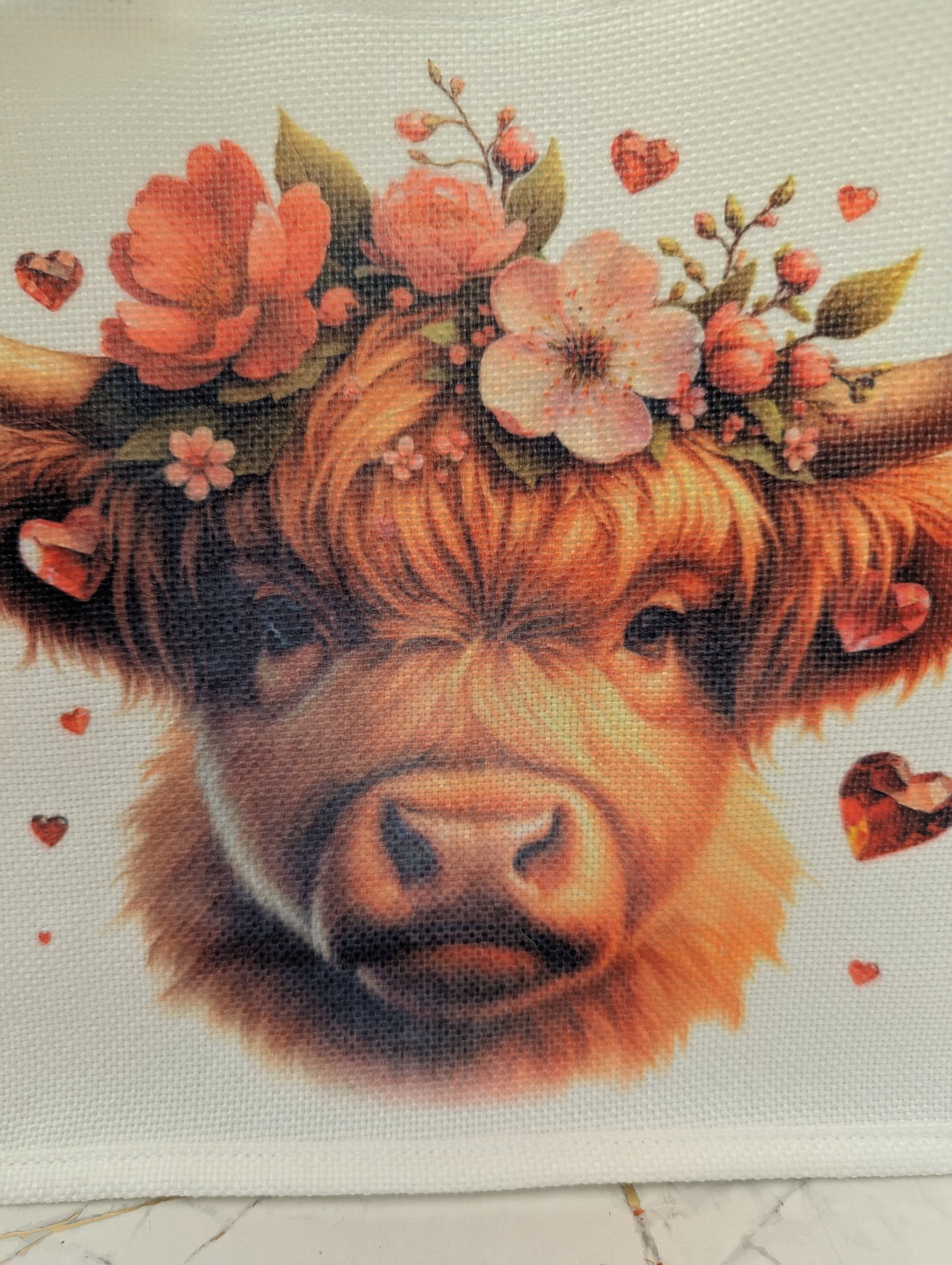 Close up detail of highland cow image with floral crown and hearts printed on linen effect tote bag