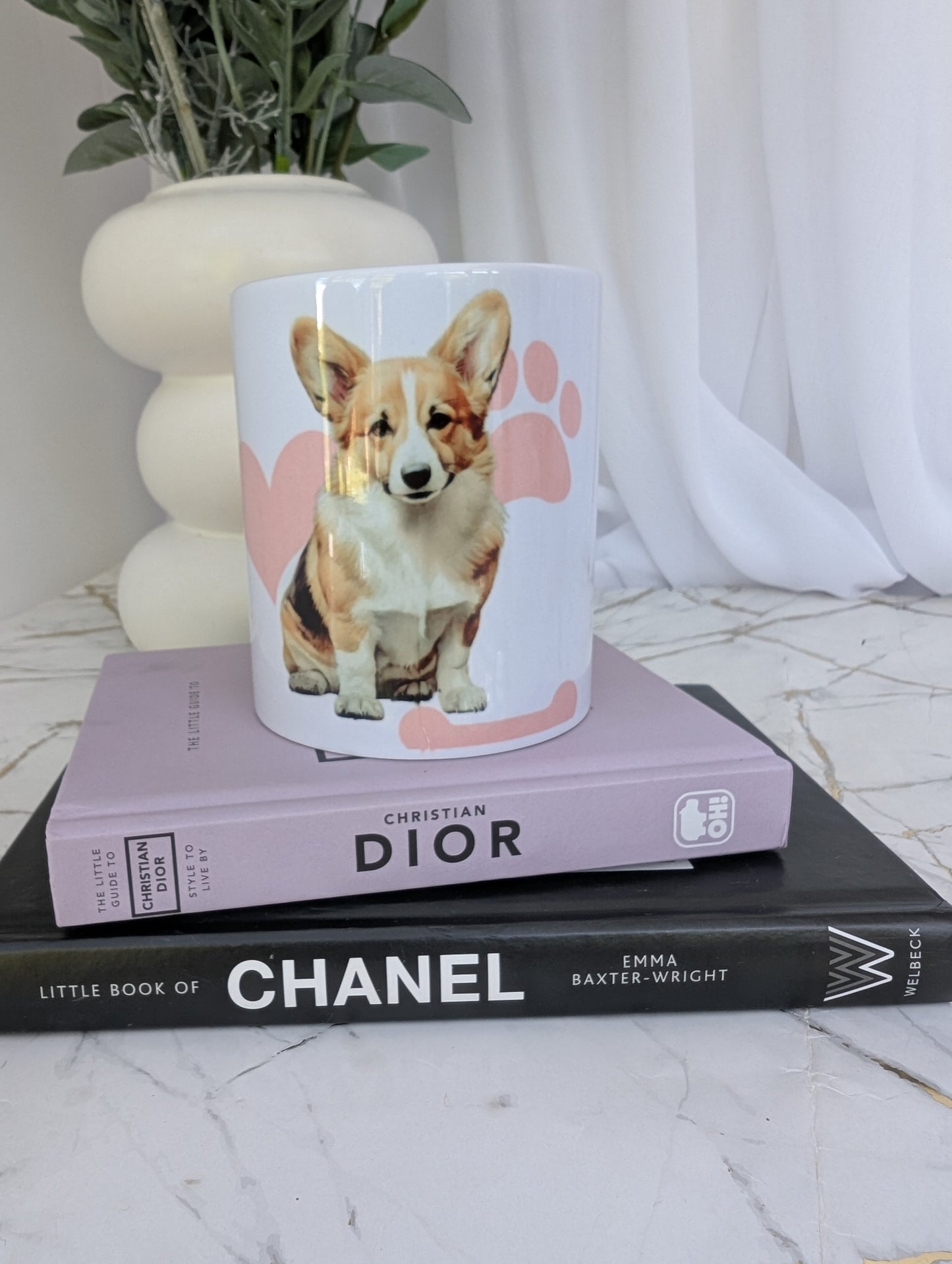 Front view of white Pembrokeshire Corgi mug with pink pawprint, heart and bone background