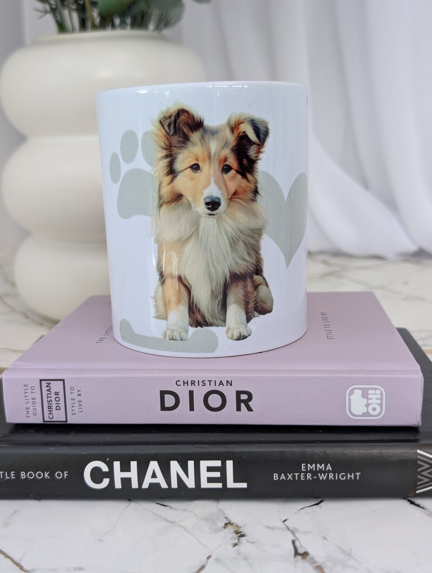 White ceramic Border Collie mug, with watercolour style image of Border collie against a background of soft grey hearts, pawprints and bones