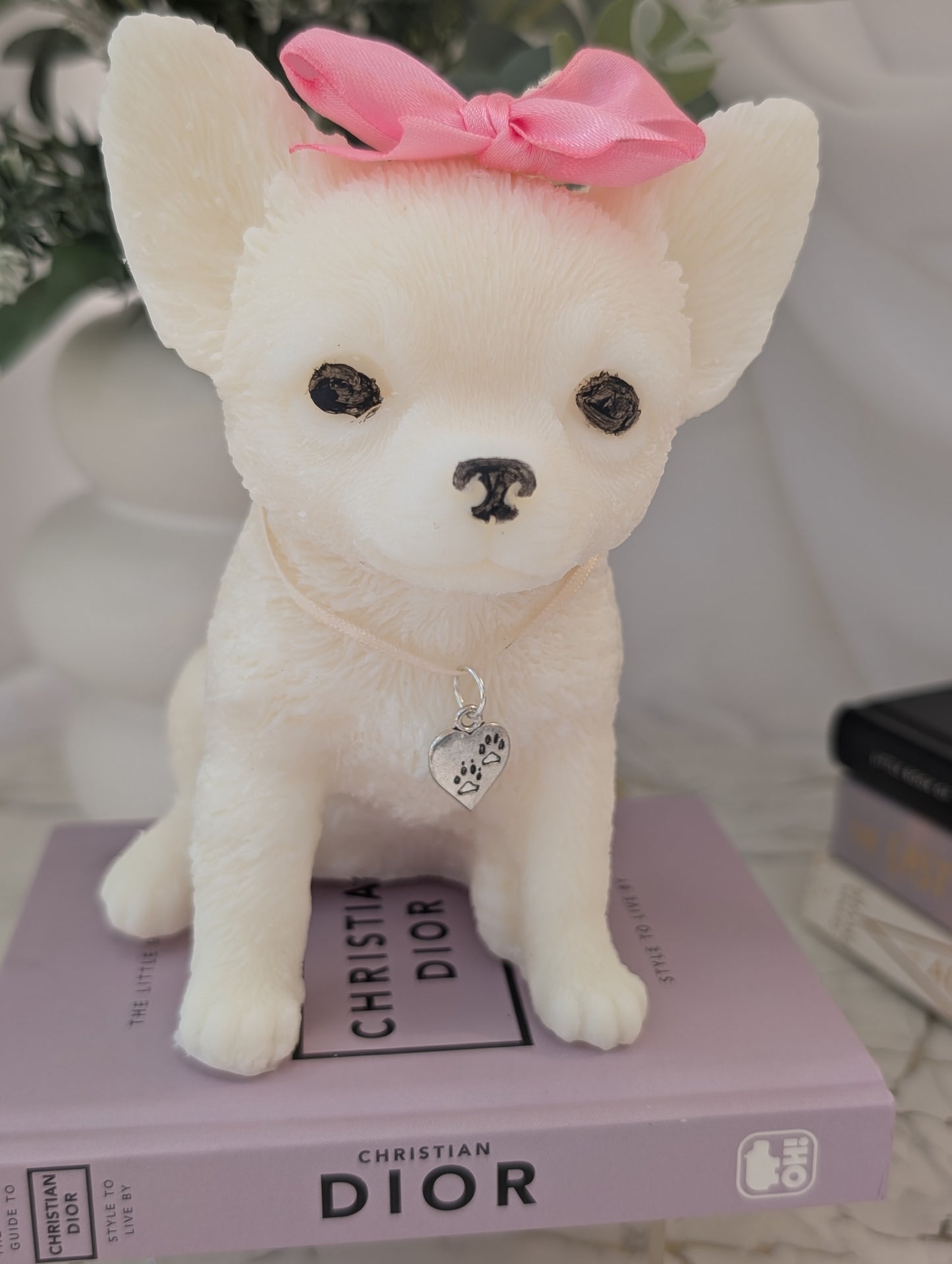 Front view of 14cm Chihuahua candle made from coconut and rapeseed wax, wearing small decorative charms and sculpted in a seated pose