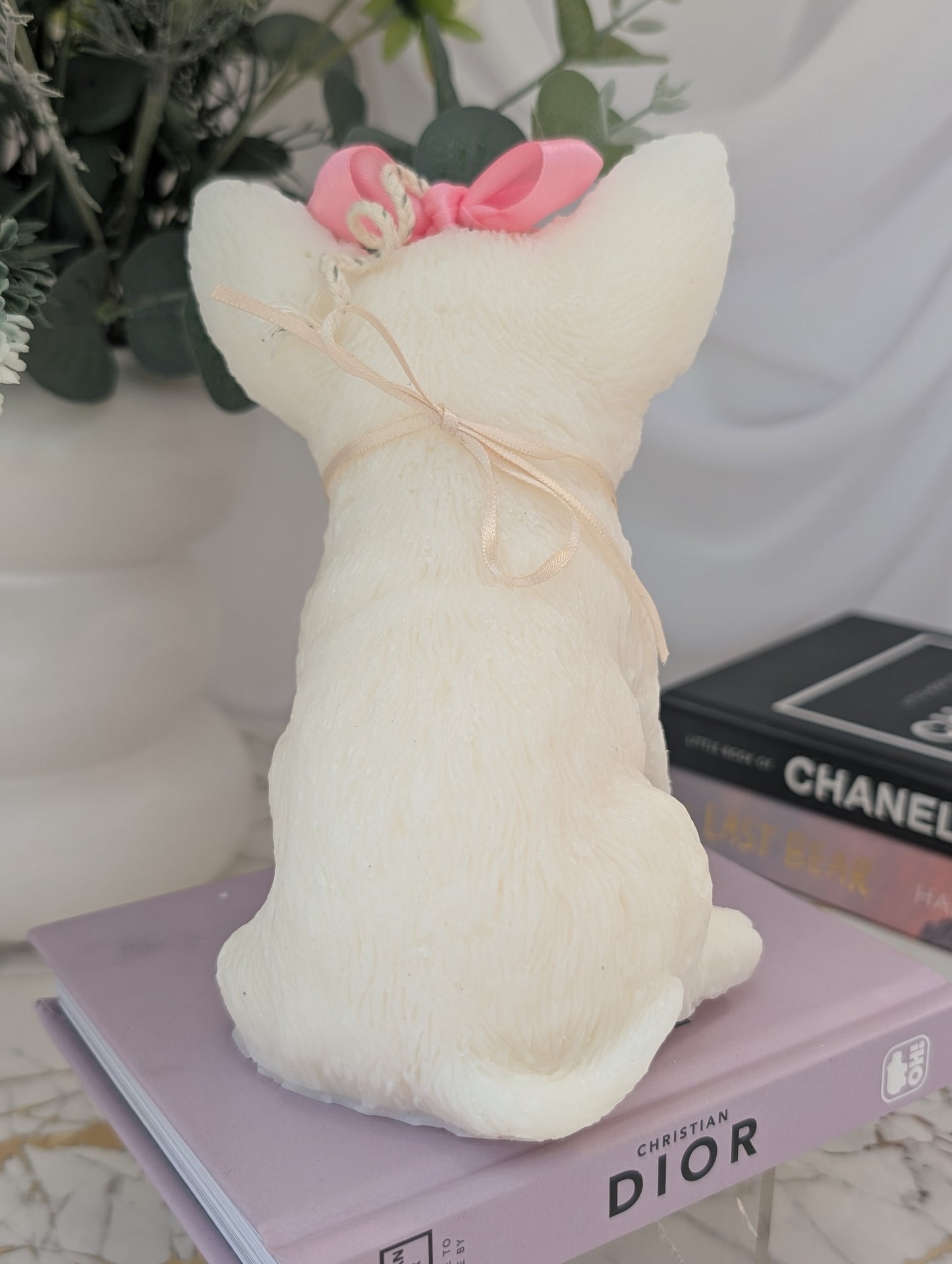 Rear view of Chihuahua candle displaying curled tail, sculpted back, and smooth wax finish with subtle charm detail visible from behind