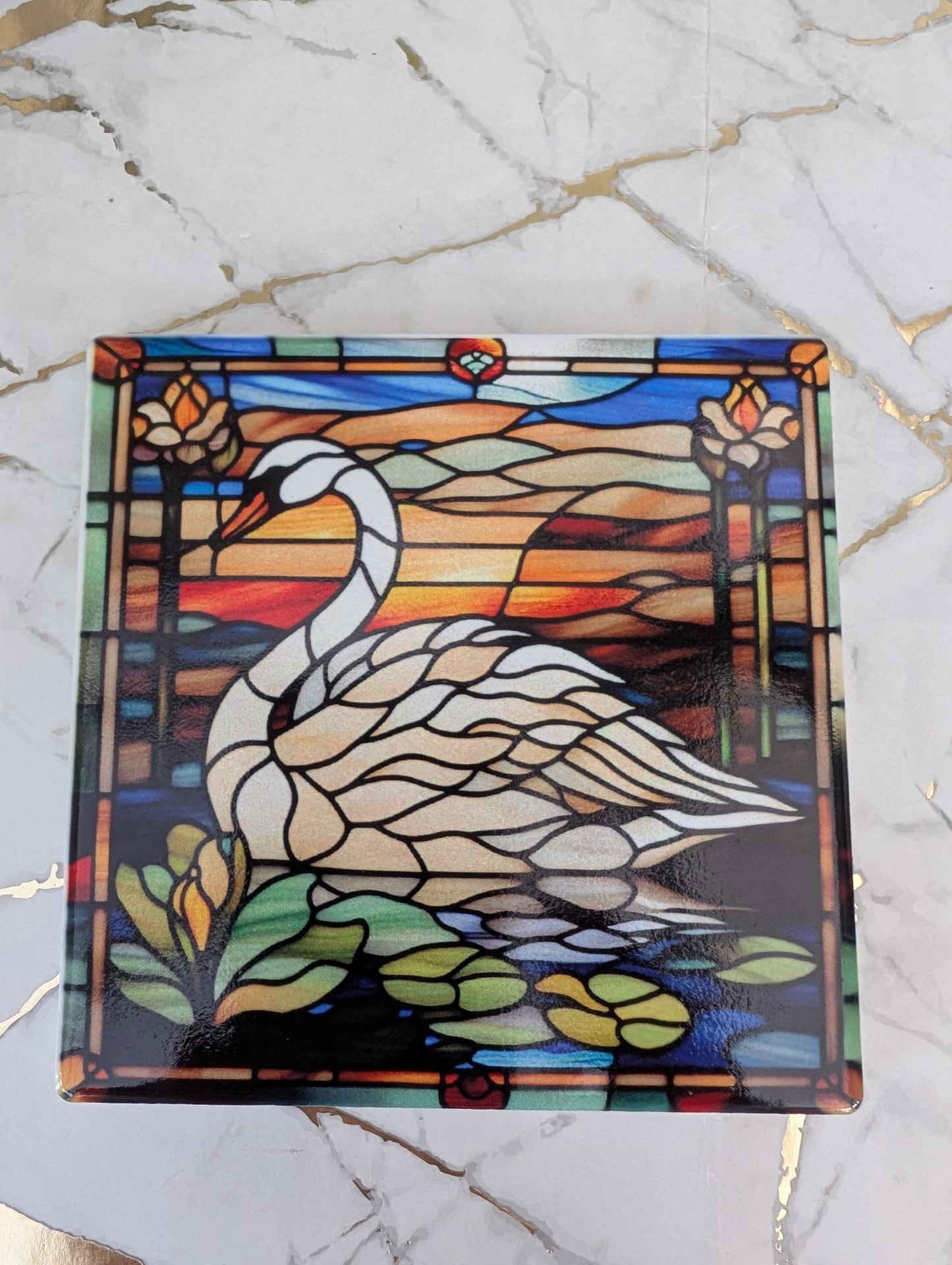 Detailed top view of a square swan stained glass effect ceramic coaster on a marble surface