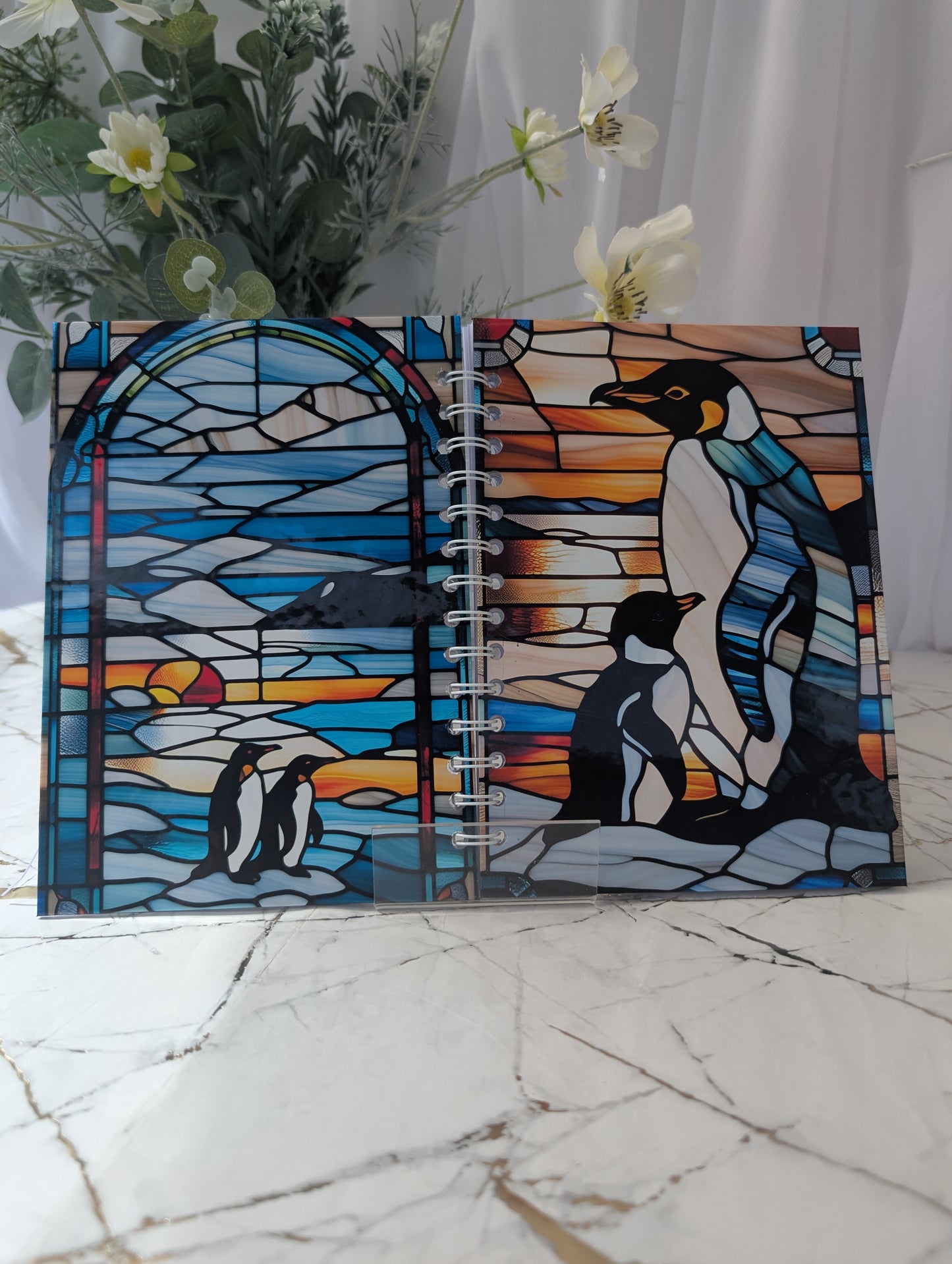 Penguin Notebook open to show front and back covers of Penguins in a stained glass style