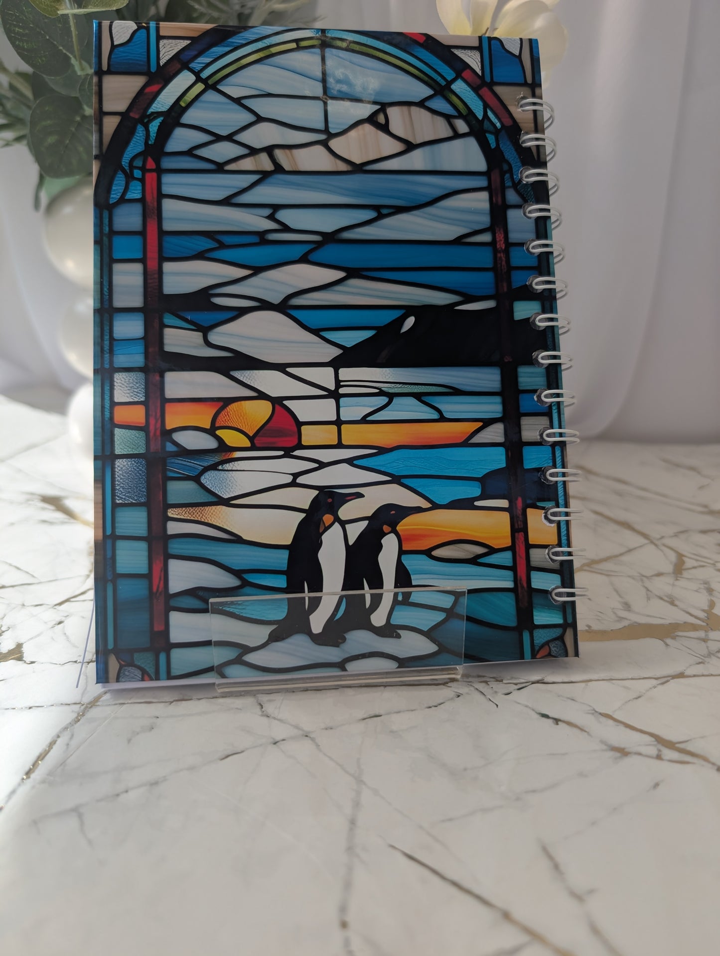 Back cover of penguin notebook with stained glass design featuring penguins in the antarctic