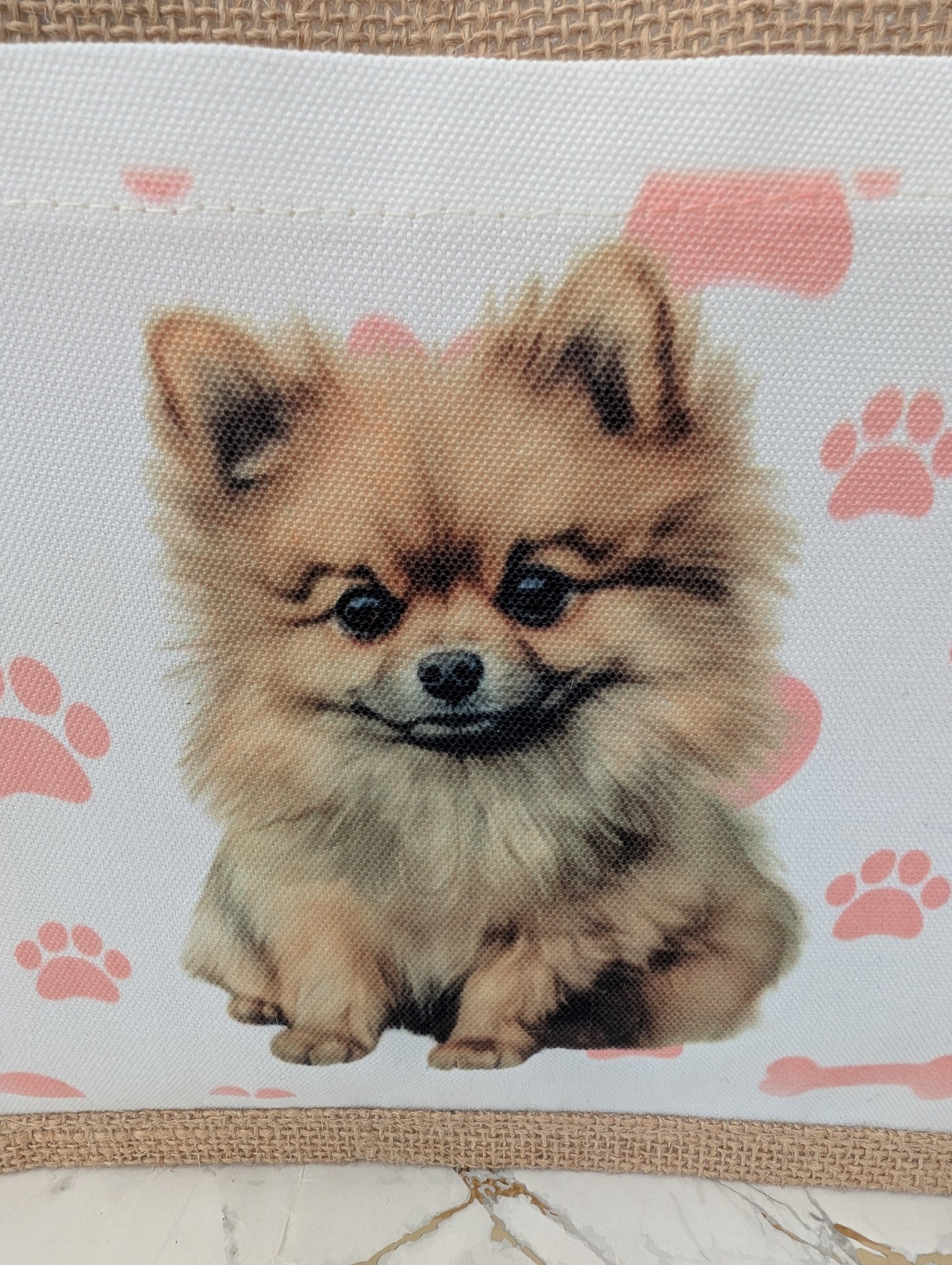 close up of eco friendly jute tote bag with cream front pocket printed with Pomeranian dog and background of pink pawprint, hearts and bones