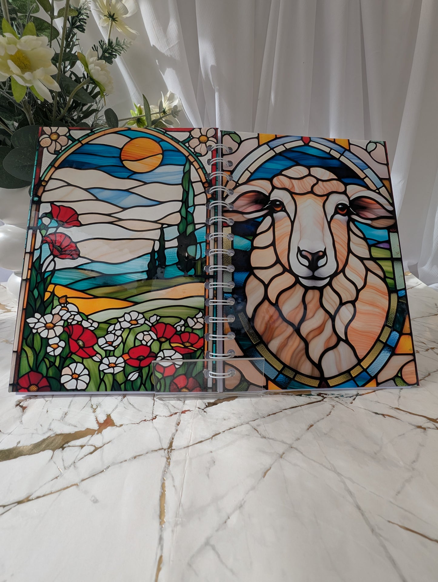 Front and back view of colourful A5 handmade glossy sheep notebook with faux stained glass design, shown open to display both covers.