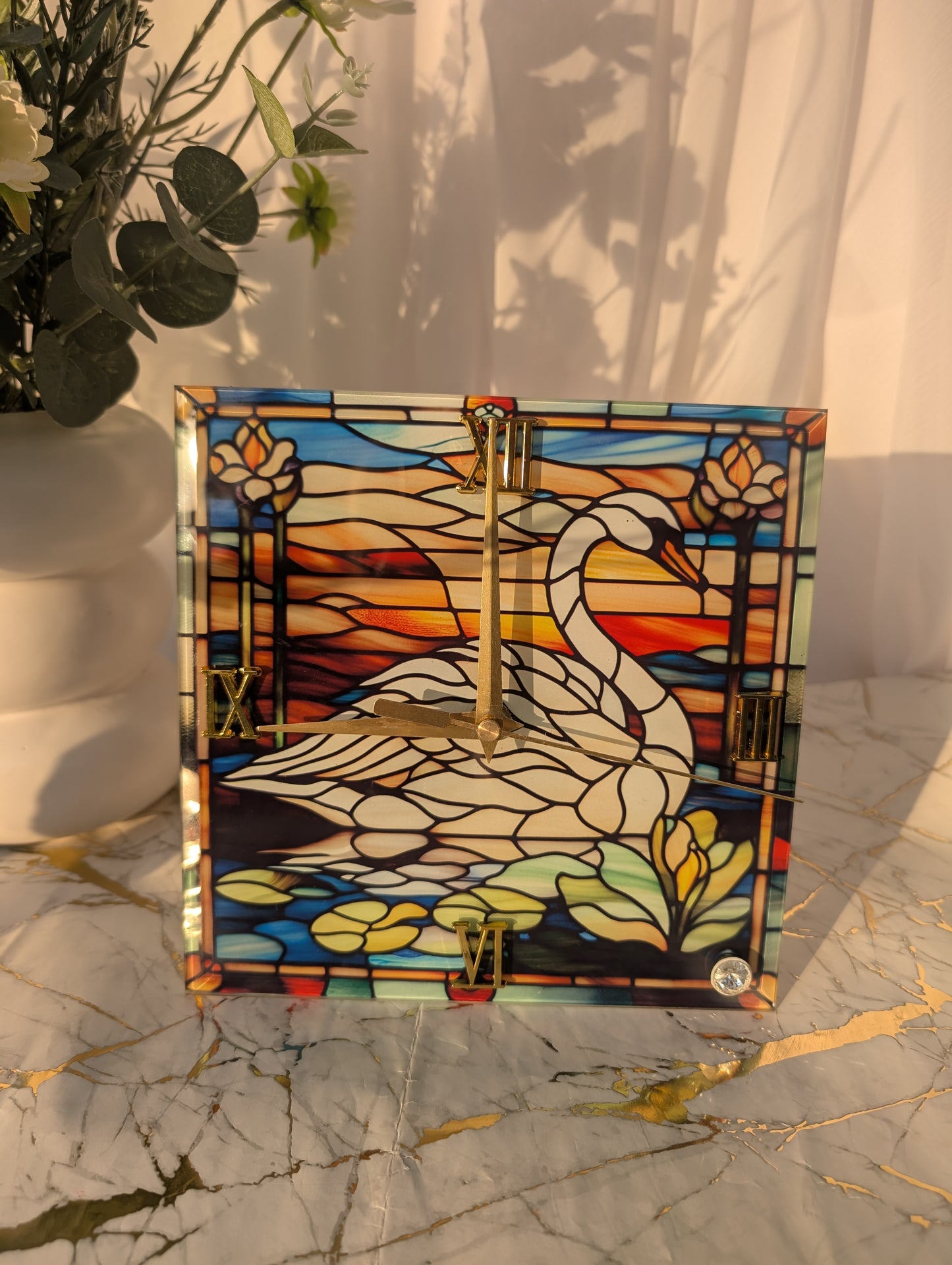 Handmade swan clock featuring colourful stained glass effect image of a swan on a lily strewn lake, perfect for home décor or gifting