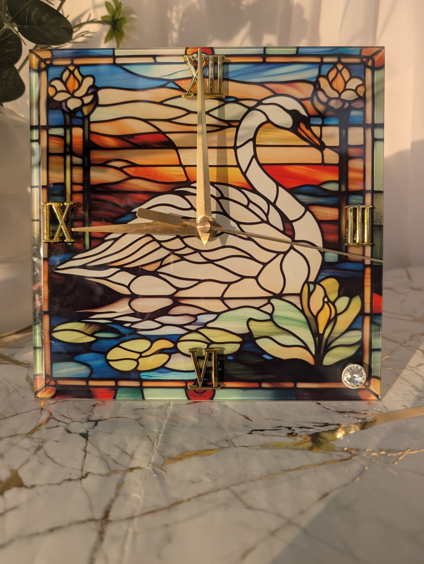 Close-up of 20cm x 20cm swan clock with art glass-style detailing and sleek freestanding base.