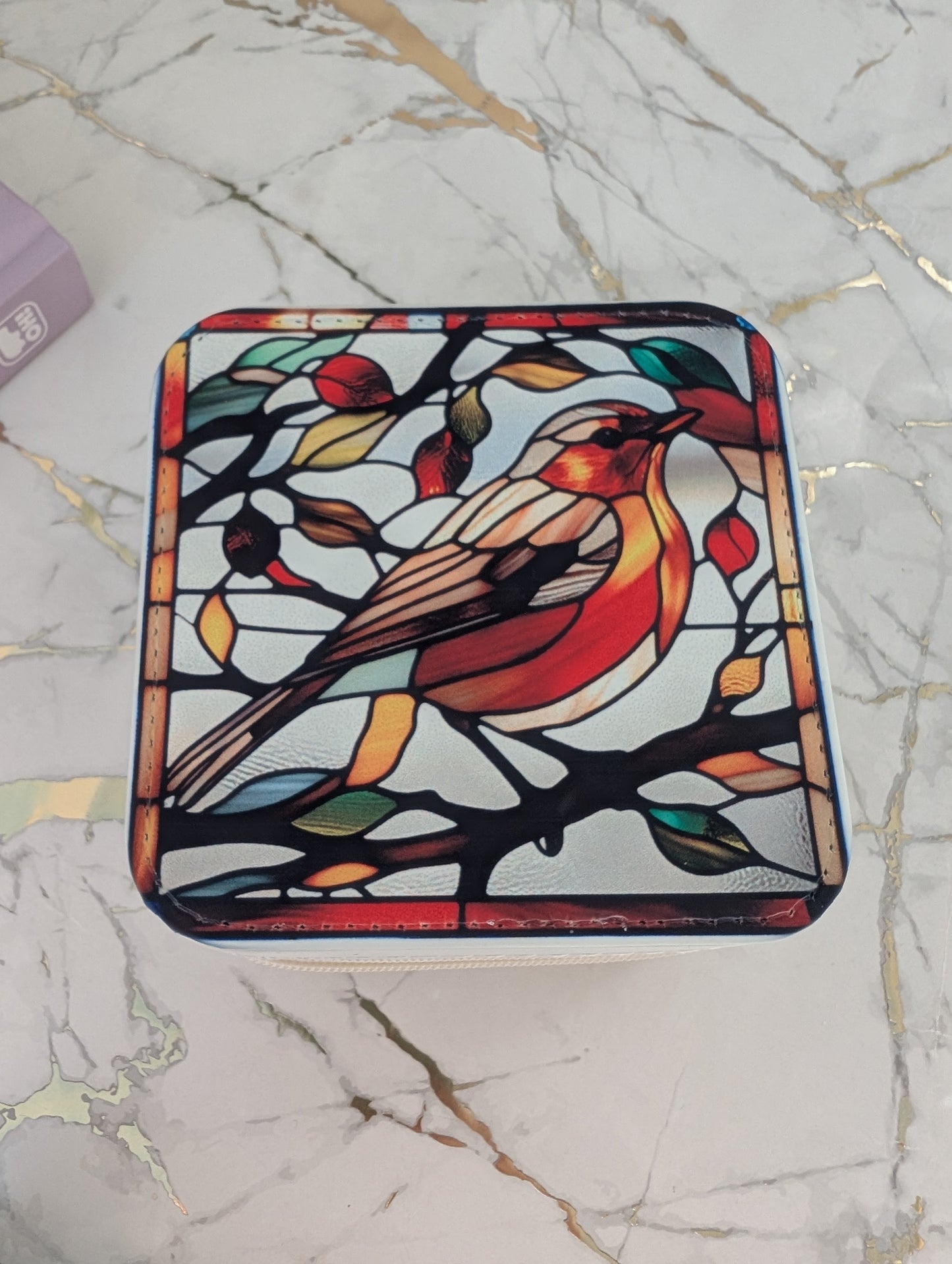 Top view of travel jewellery box in cream faux leather with stained glass robin design