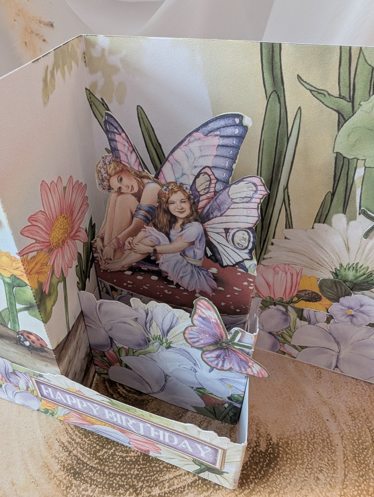 Pop-up card with fairy and butterfly design on a floral background