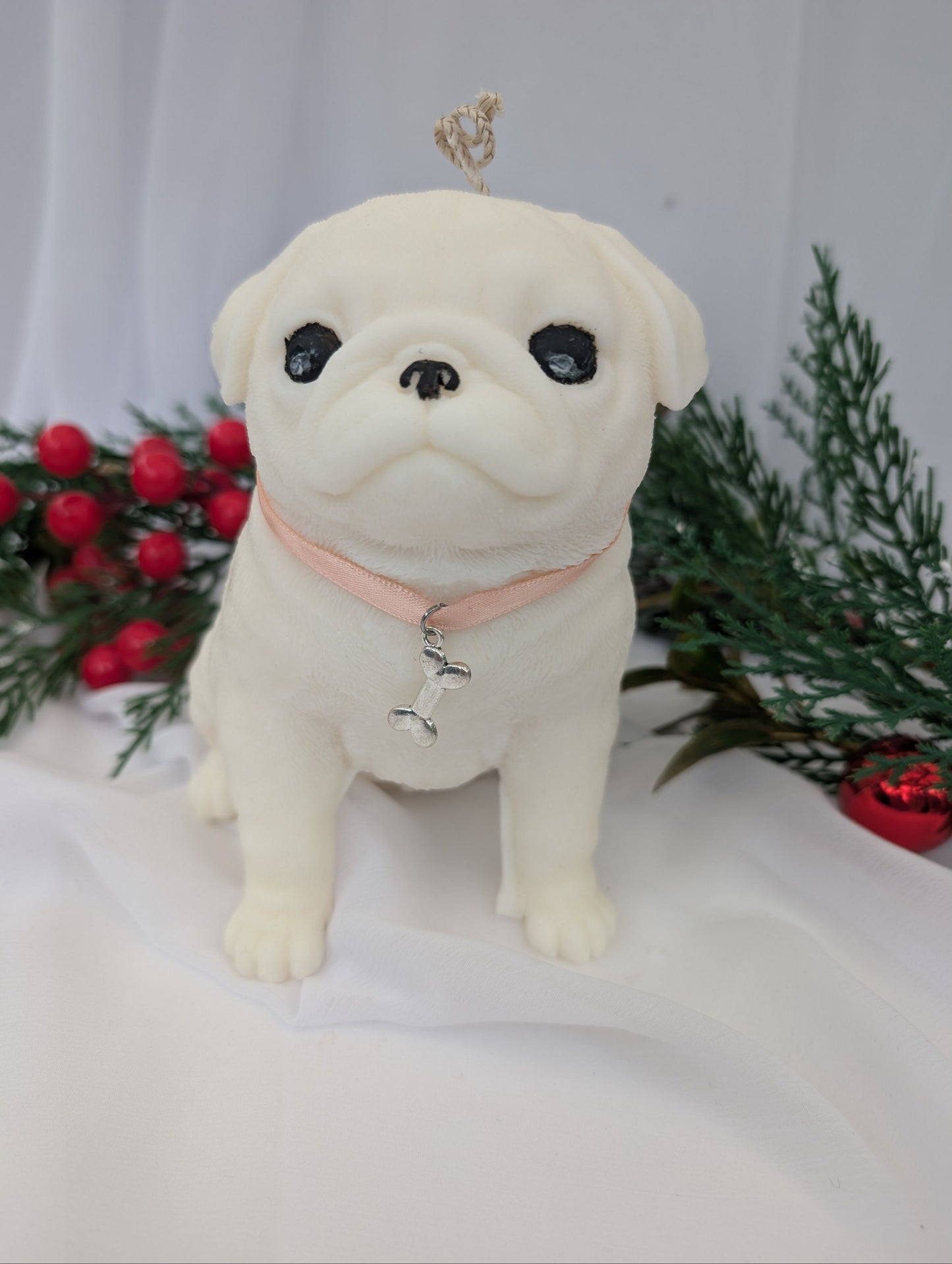 White coconut and rapeseed wax blend moulded Pug candle with ribbon and bone charm around his neck