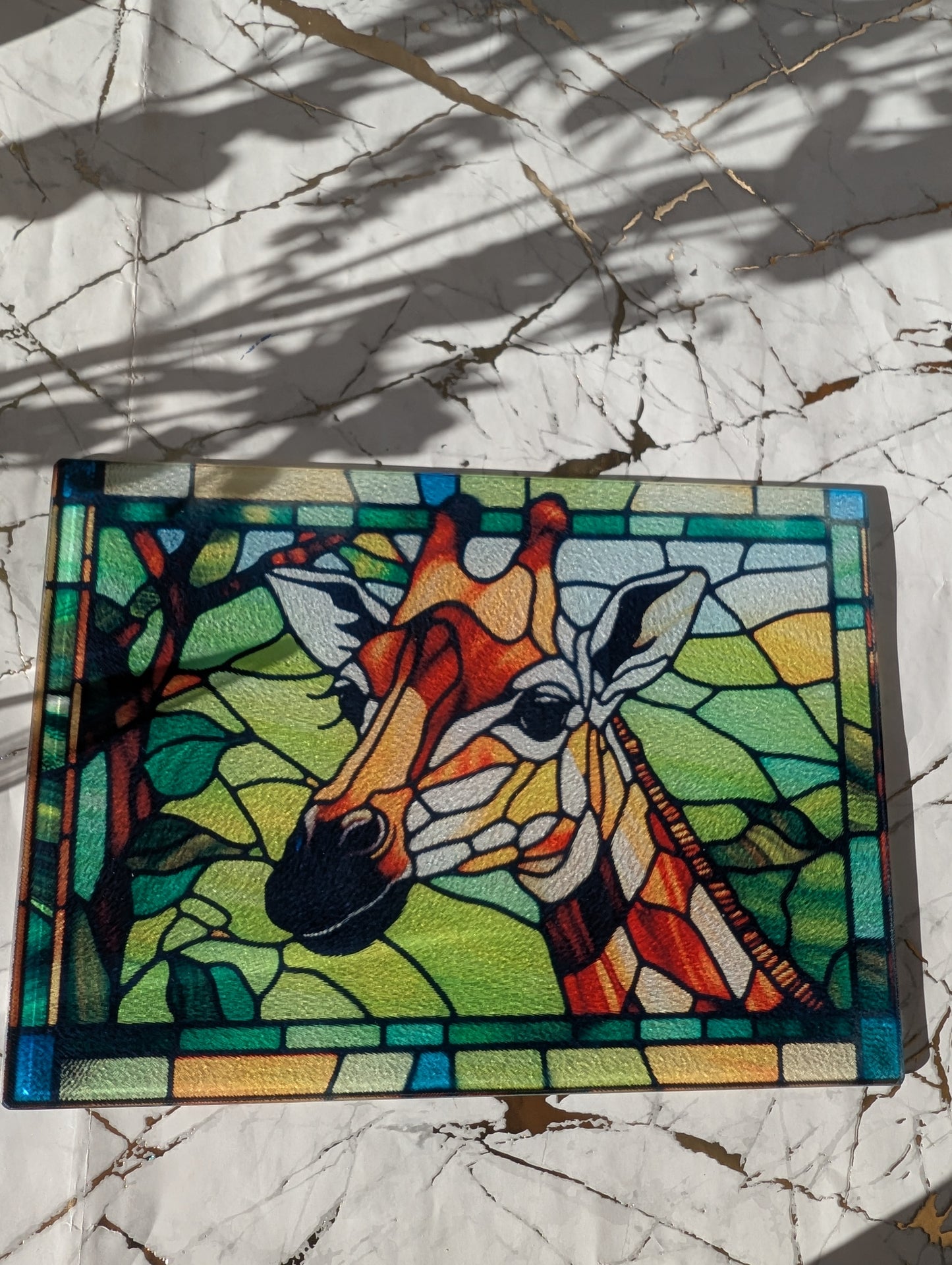 overhead view of stained glass style Giraffe chopping board. Made from toughened glass it's the perfect gift for giraffe lovers