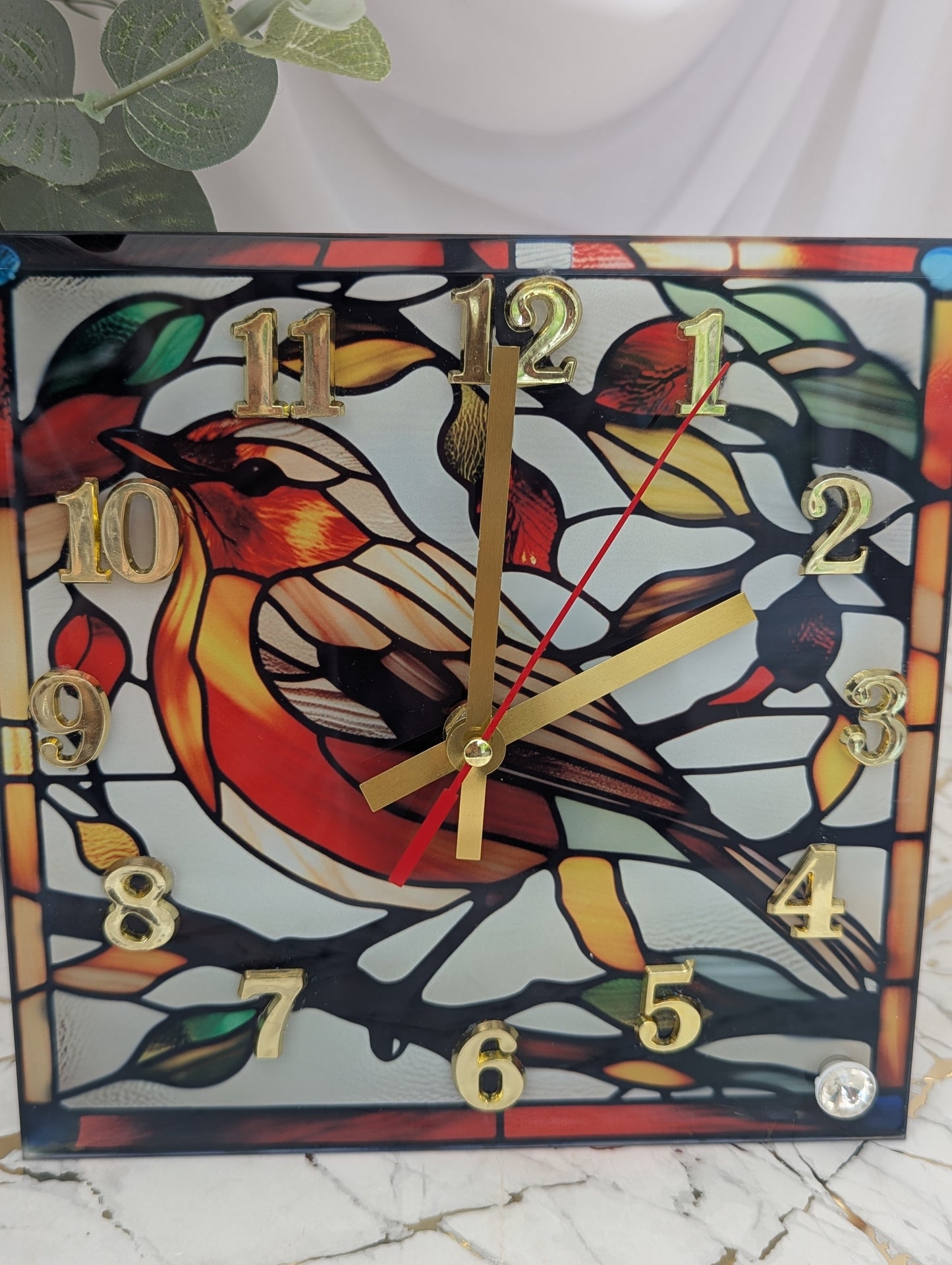 Close-up of robin clock showing detailed art glass pattern and rustic woodland charm.