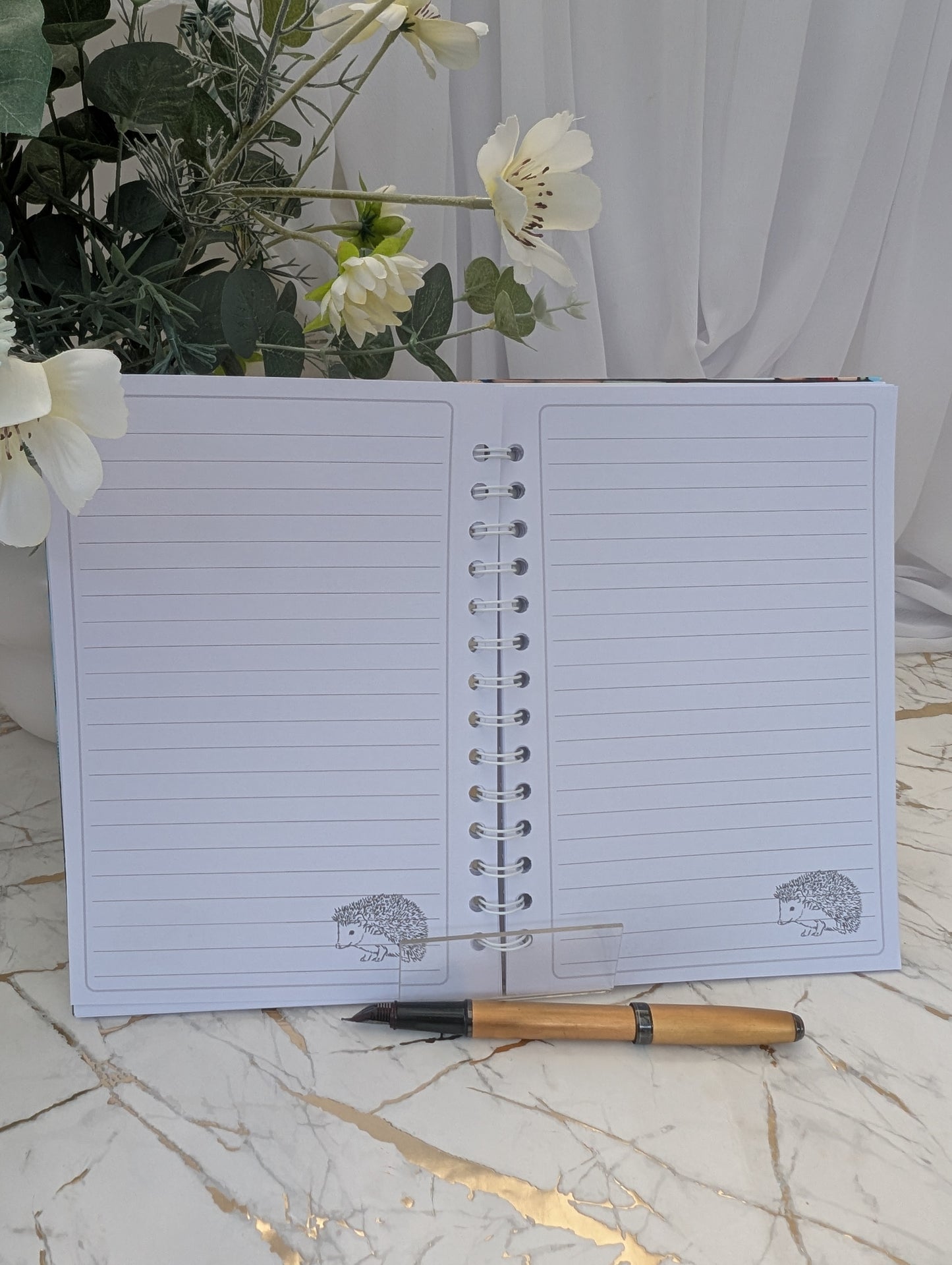 Stained glass style hedgehog notebook - open to show inside pages. Lined with hedgehog image on bottom left hand side of each page. Quality stationery gift for Hedgehog lovers