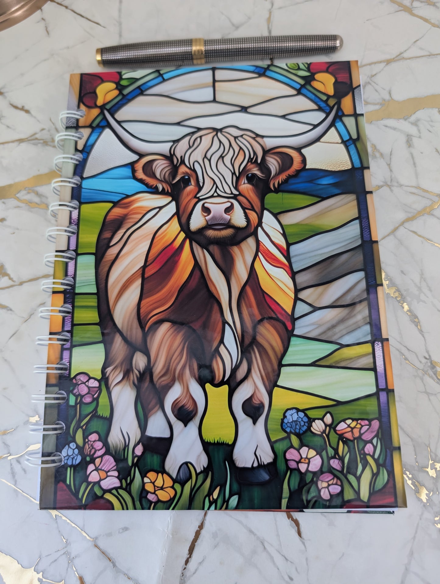 close up of stained glass highland cow notebook cover.