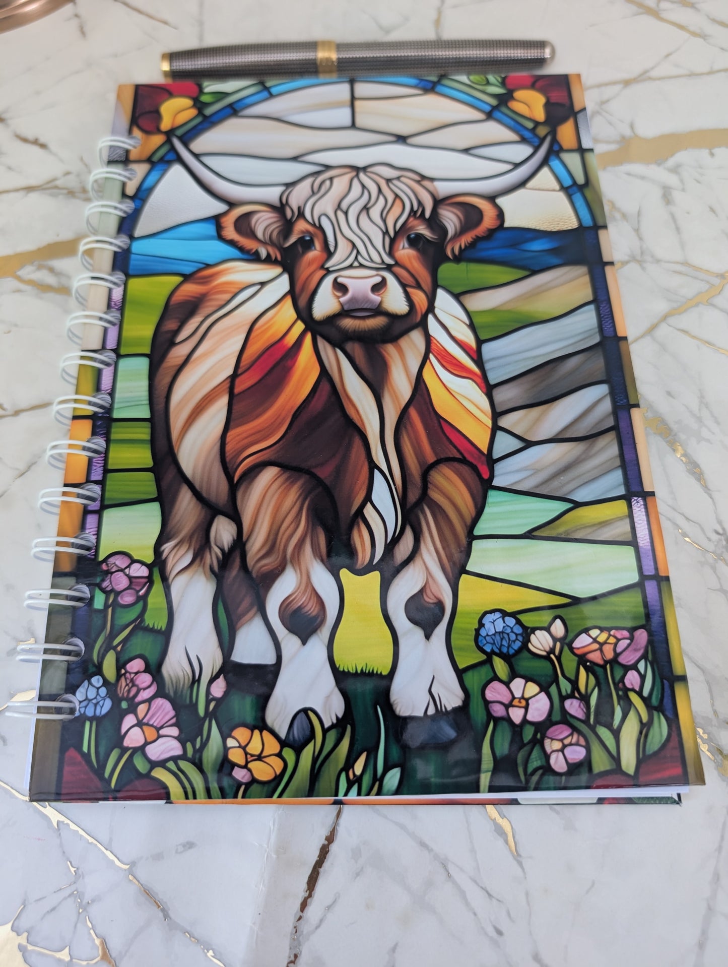 Top view of stained glass style Highland Cow notebook