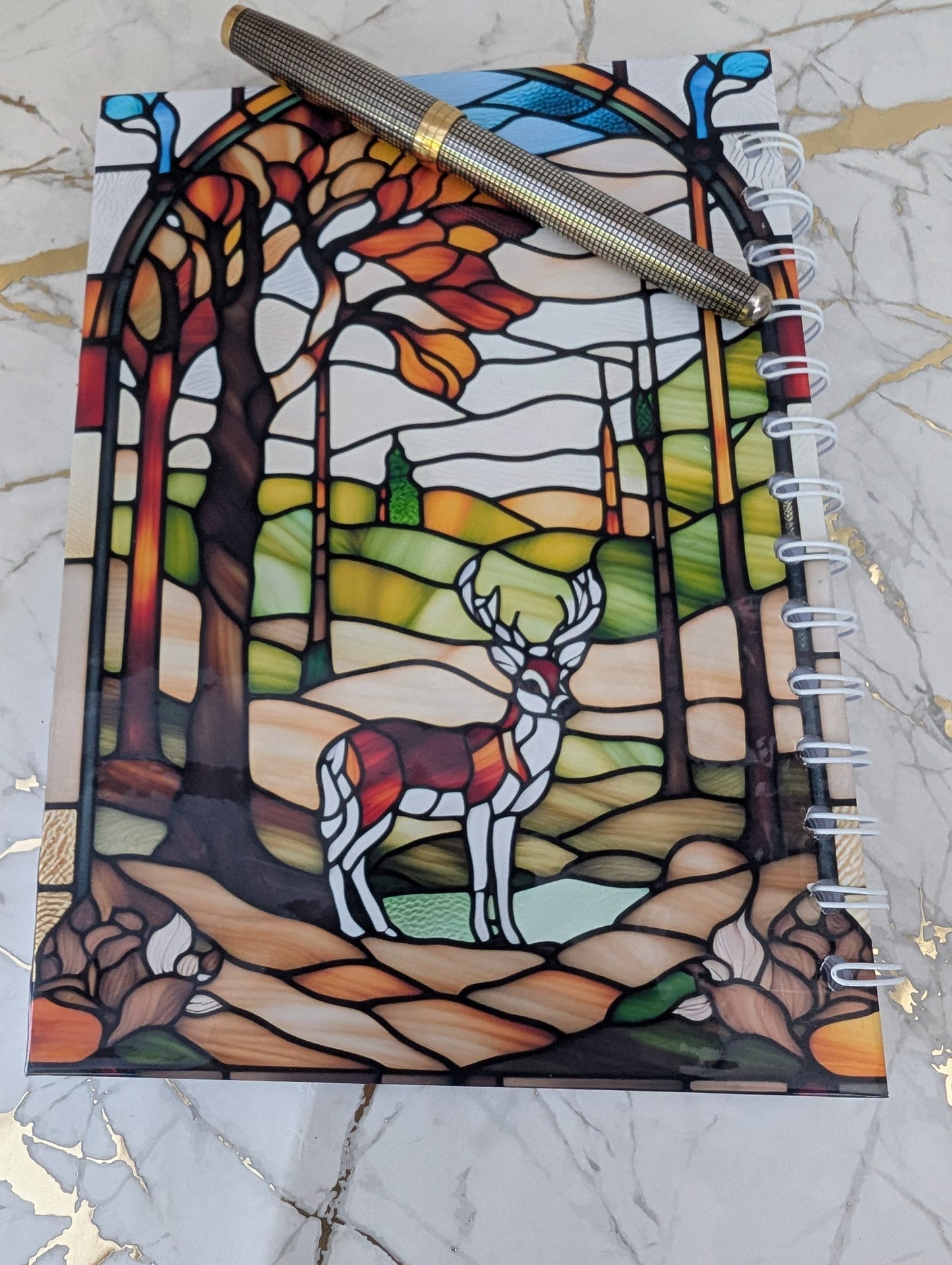 Back cover of stained glass highland cow notebook - showing forest scene with stag