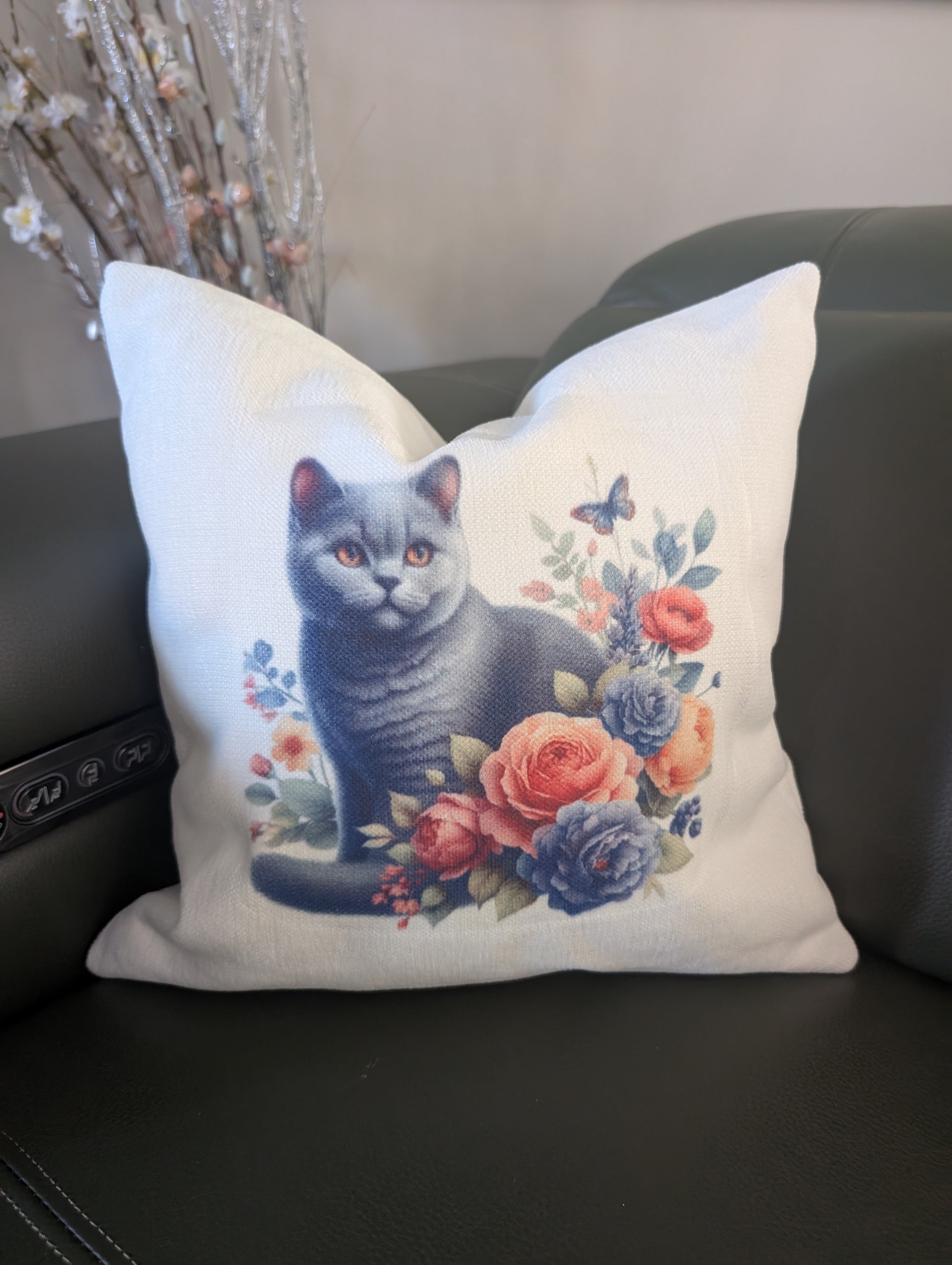 close up of Black Cat Cushion on cream linen effect fabric with floral design