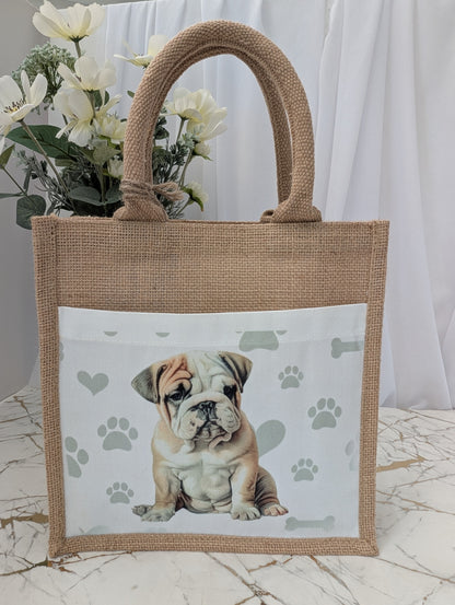 Bulldog tote bag made of sustainably sourced jute.  It has a cream front pocket printed with cute bulldog image against a background of soft grey pawprints hearts and bones