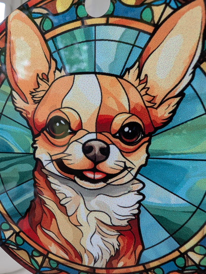 zoom close up of smiling chichuahua stained glass effect hanging ornament using blues yellows and browns.  9cm diameter hanging on a red ribbon 