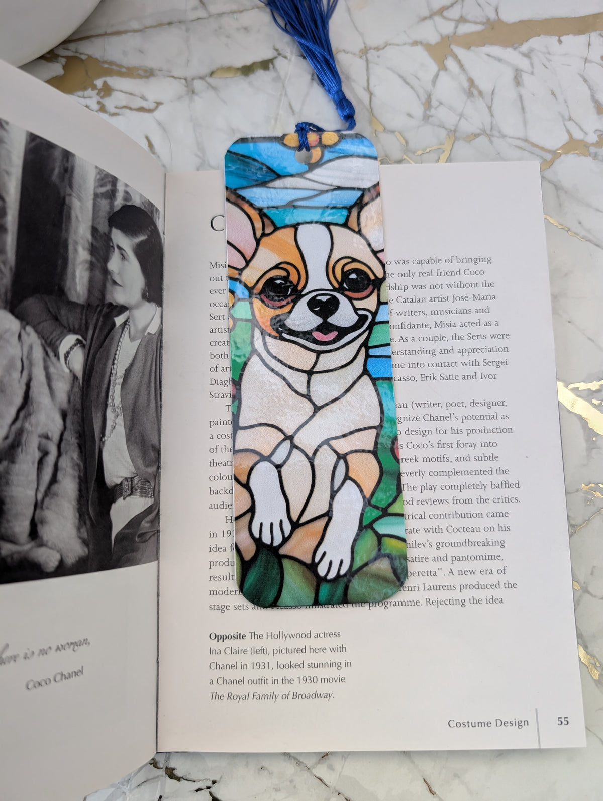 Stained Glass Style Chihuahua bookmark with blue tassel by Paws and Glow.  Laminated for strength and durability and handmade in the UK.  Shown on an open book.