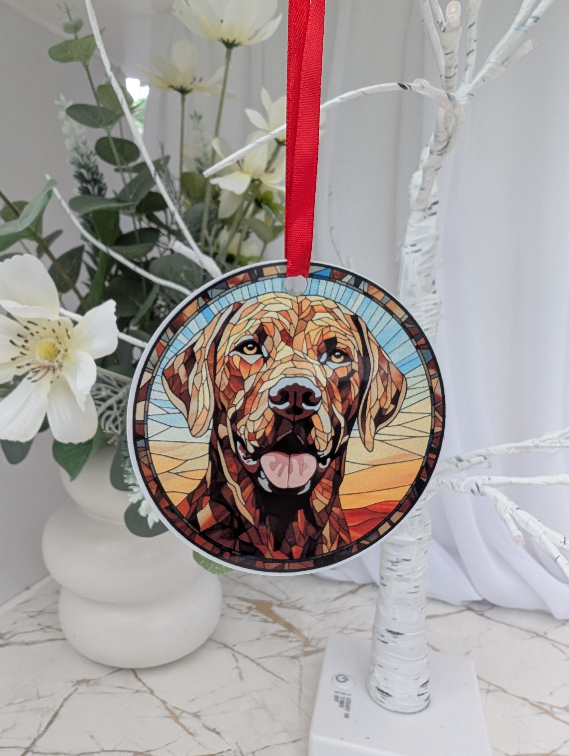 Decorative ornament with dog portrait on a branch with flowers.