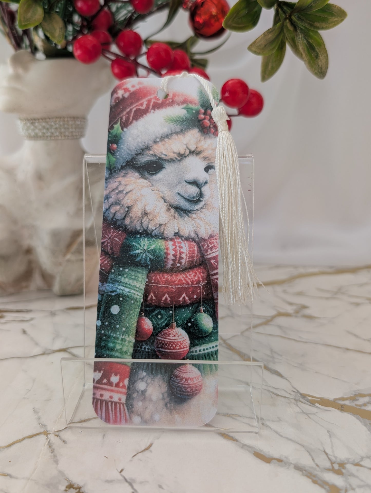 Decorative bookmark with a Christmas-themed llama design on a marble surface.