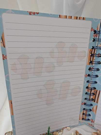 Notebook with lined pages and decorative cover featuring clownfish