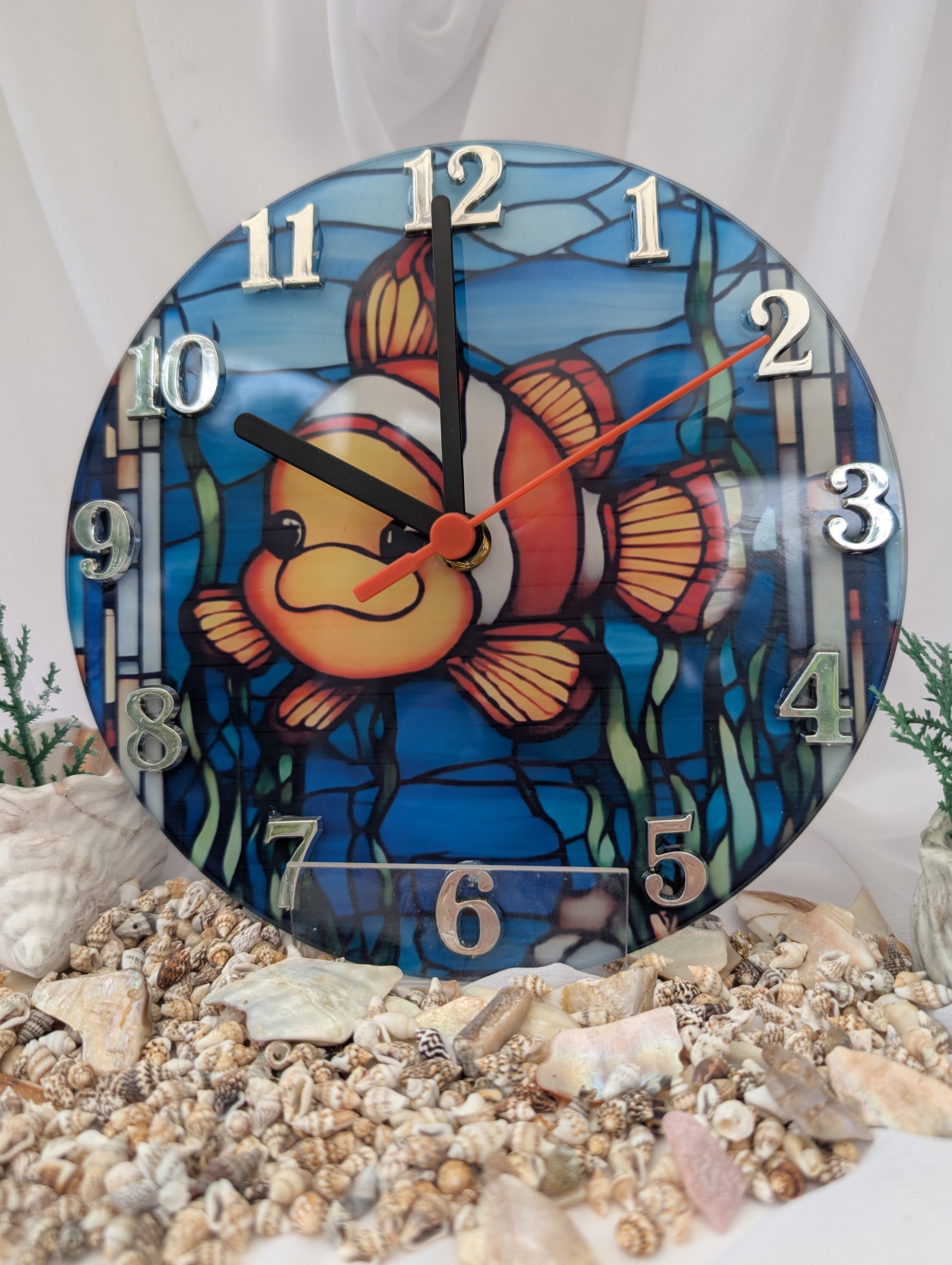 Decorative clock with a clownfish design on a white background