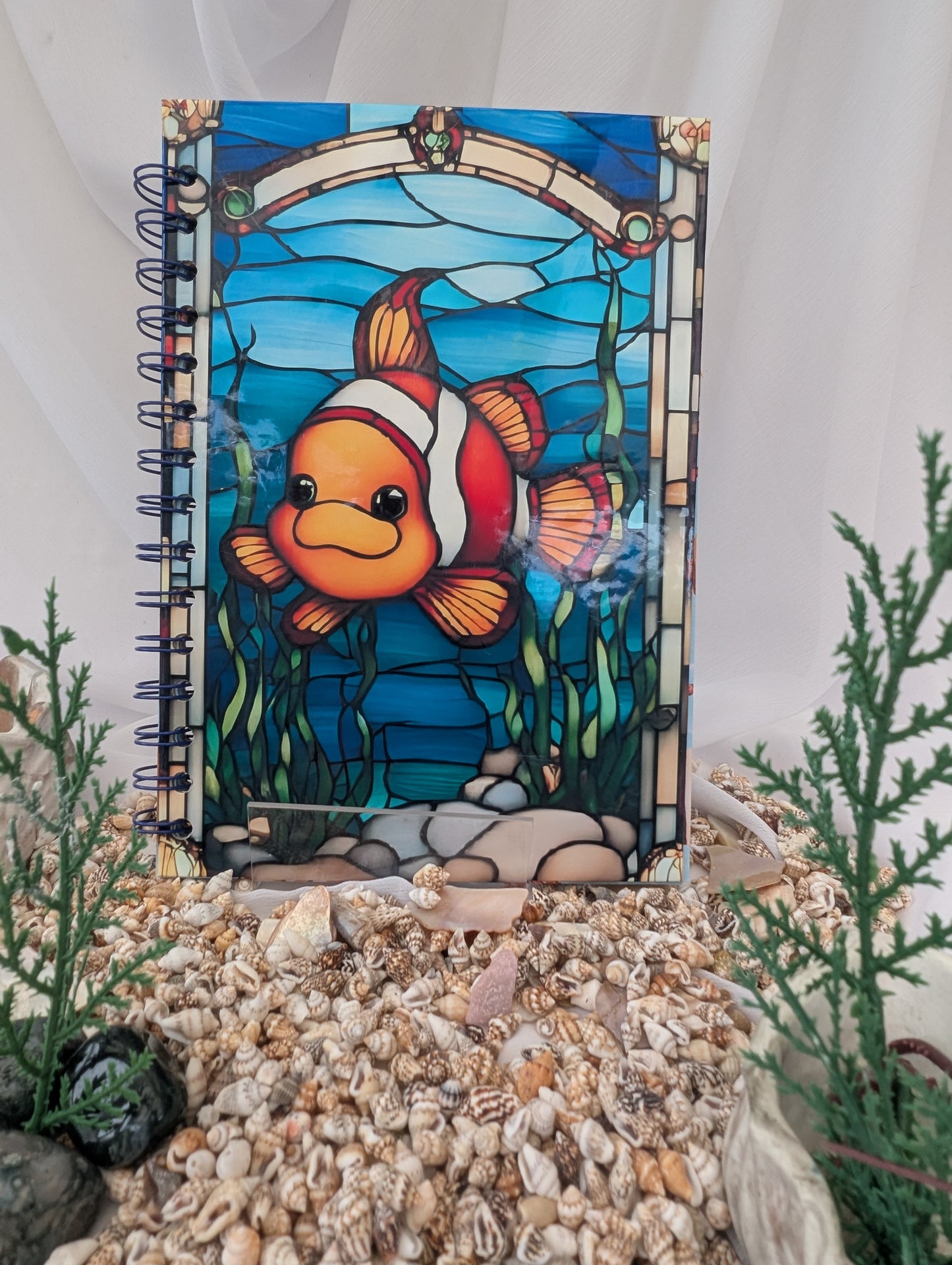 Notebook with a colorful clownfish illustration on shells