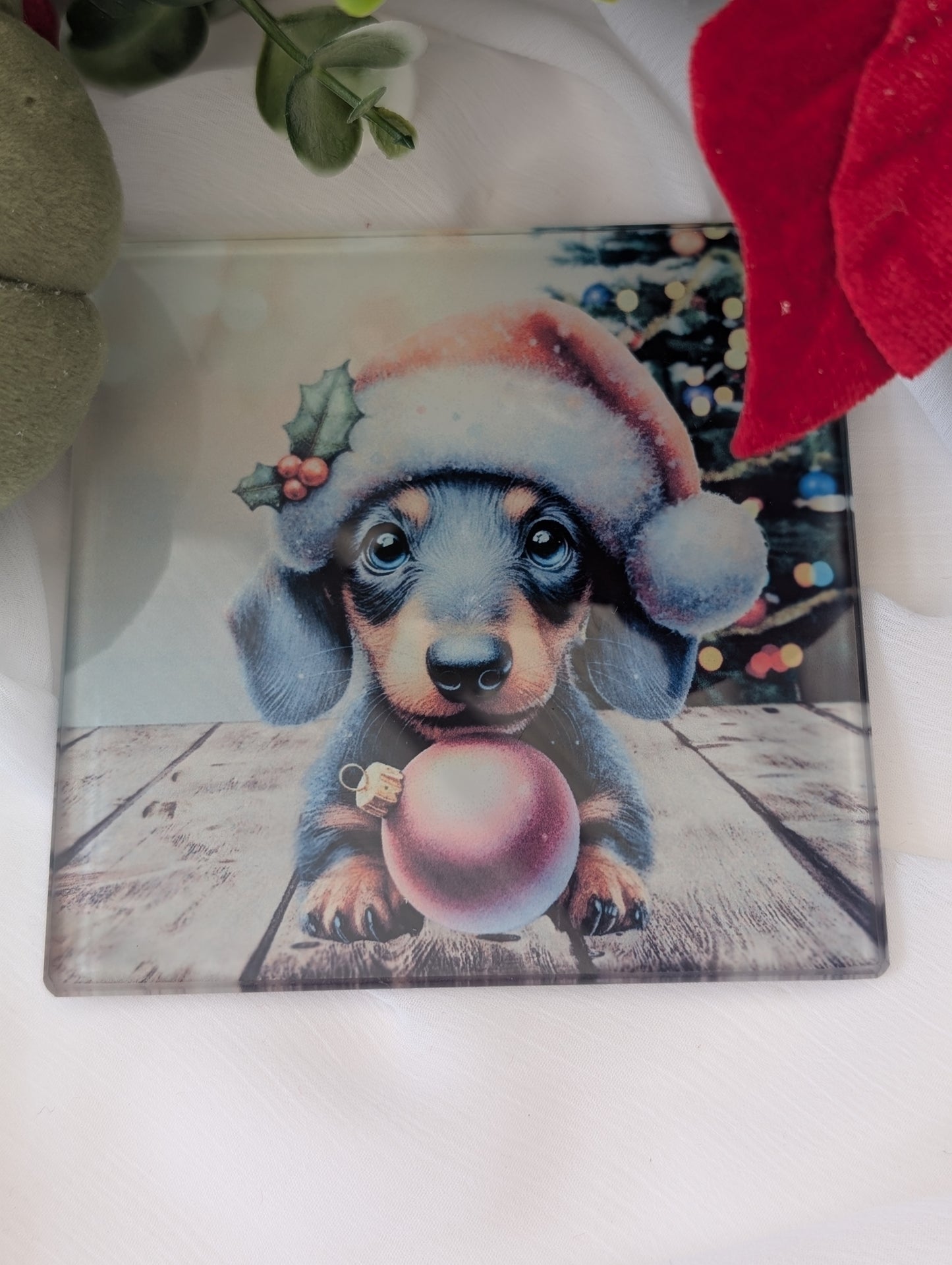 Decorative glass coaster with a Christmas-themed Dachshund puppy design holding a pink ornament.