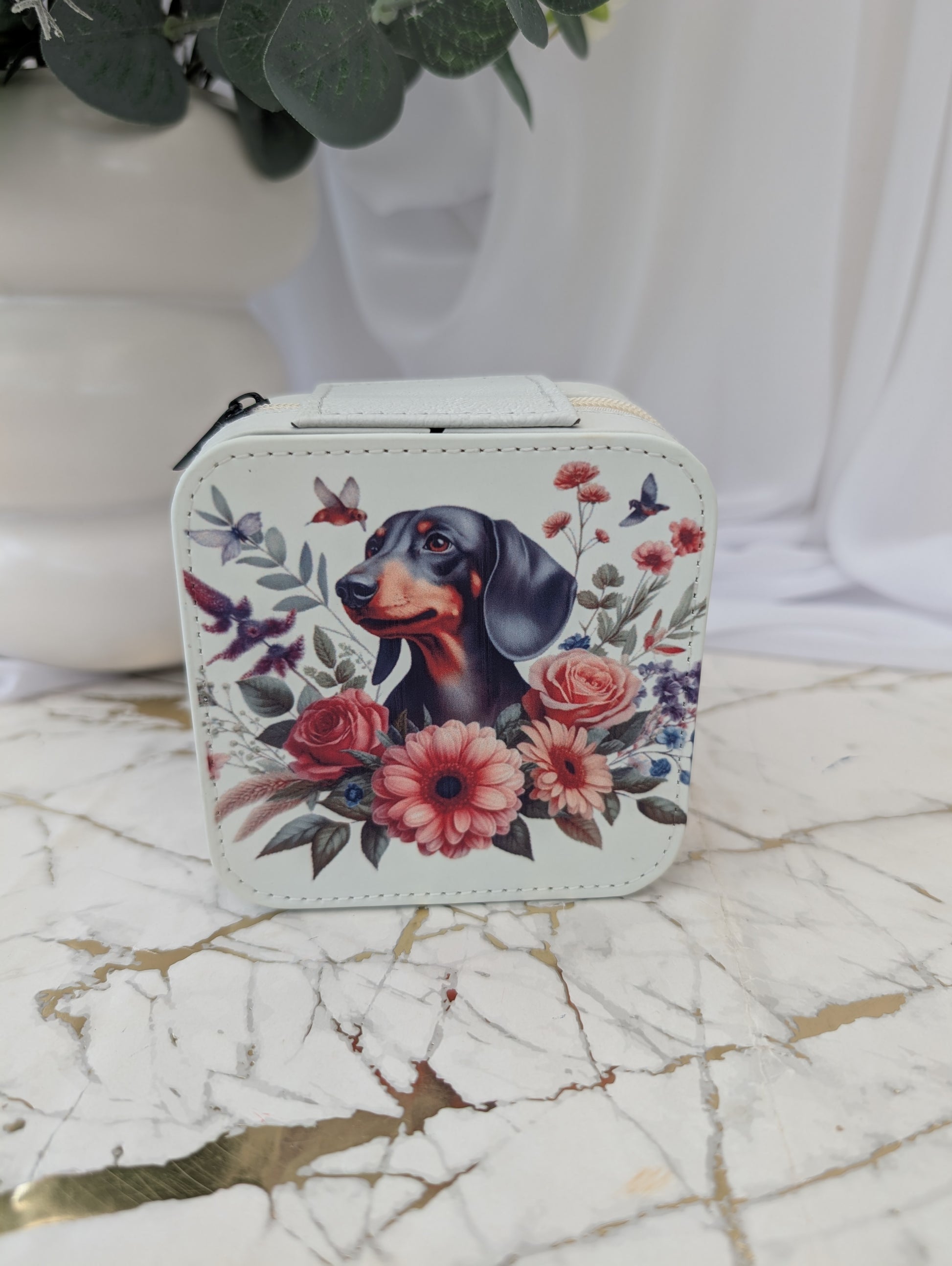 Cream faux leather travel jewellery box with dachshund and flower image on marble surface