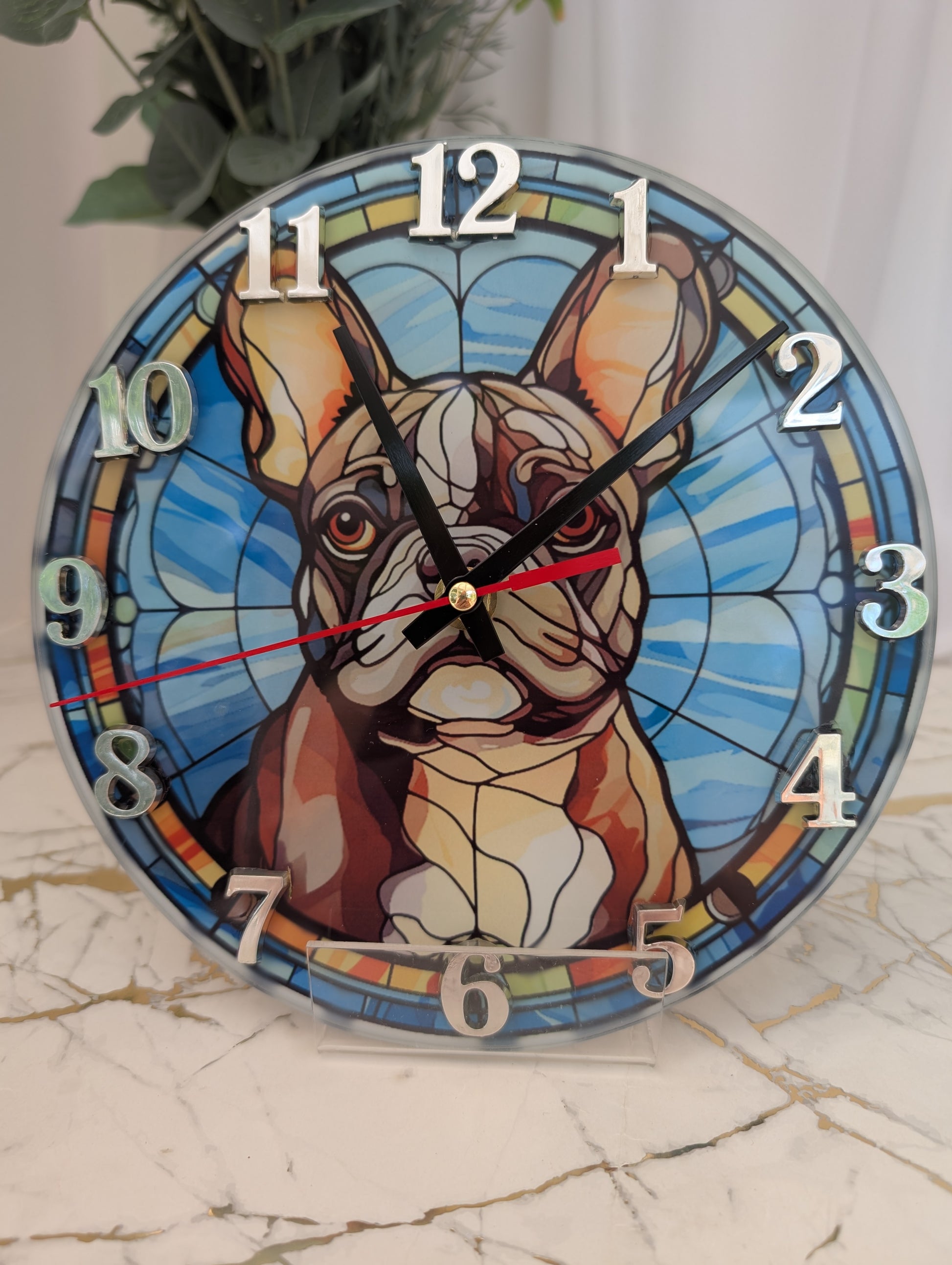 close up detail of 20cm round French Bulldog Wall clock in blue themed stained glass effect design, silver numerals and black clock hands