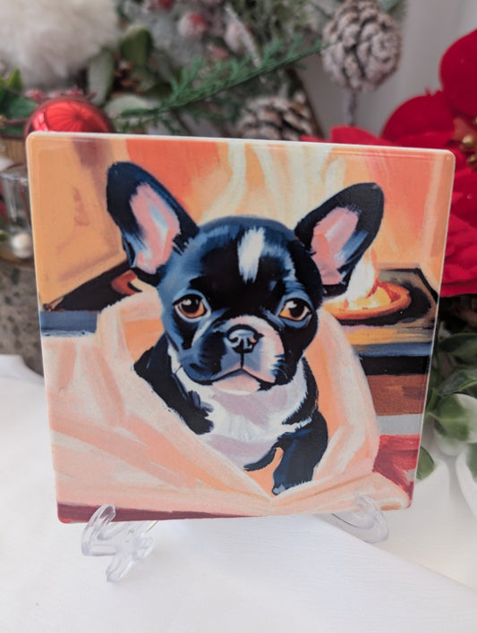 French Bulldog gift idea - glass coaster with black and white French bulldog peeping out of a blanket in front of a fire
