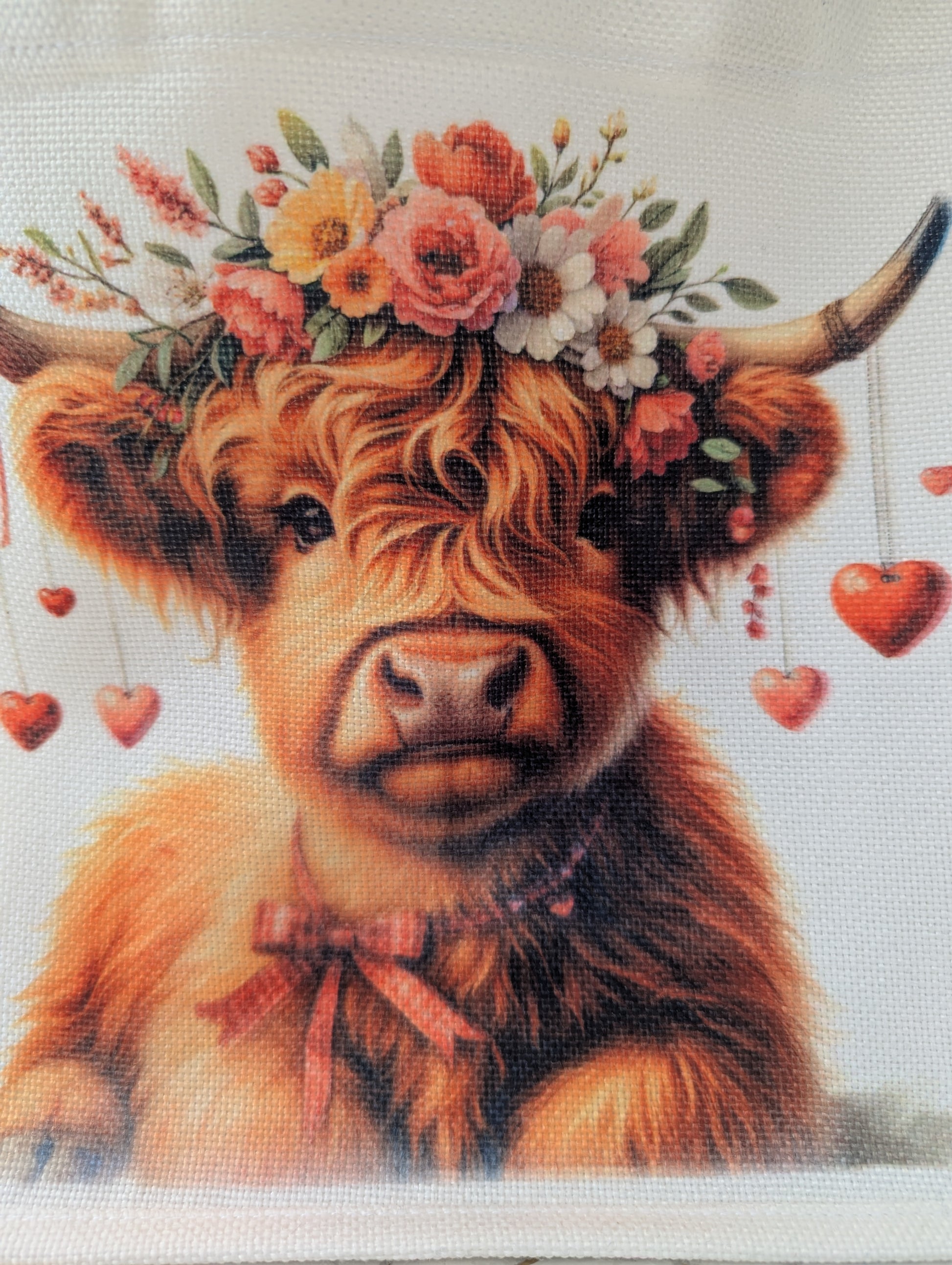 Close up detail of Highland Cow Tote bag with cow wearing a floral crown and hearts dangling from her horns