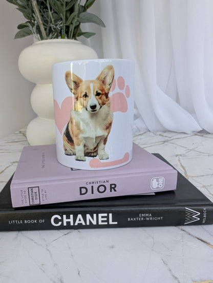 Front view of white Pembrokeshire Corgi mug with pink pawprint, heart and bone background