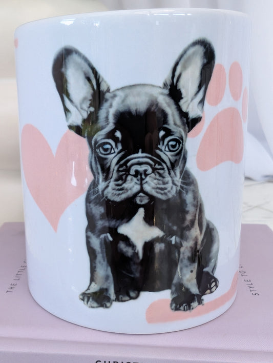 White ceramic 11oz French Bulldog mug on a background of pink hearts, paws and bones