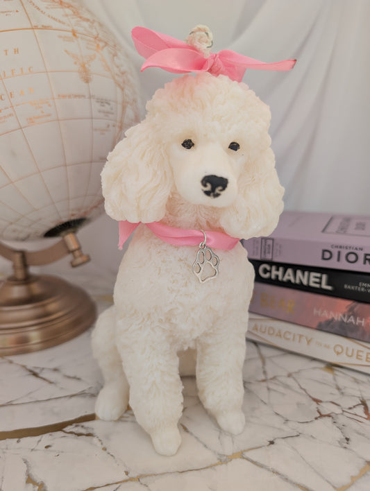 Close-up of lifelike wax poodle candle with delicate charm around neck and on head, showing fine detailing in fur and facial feature