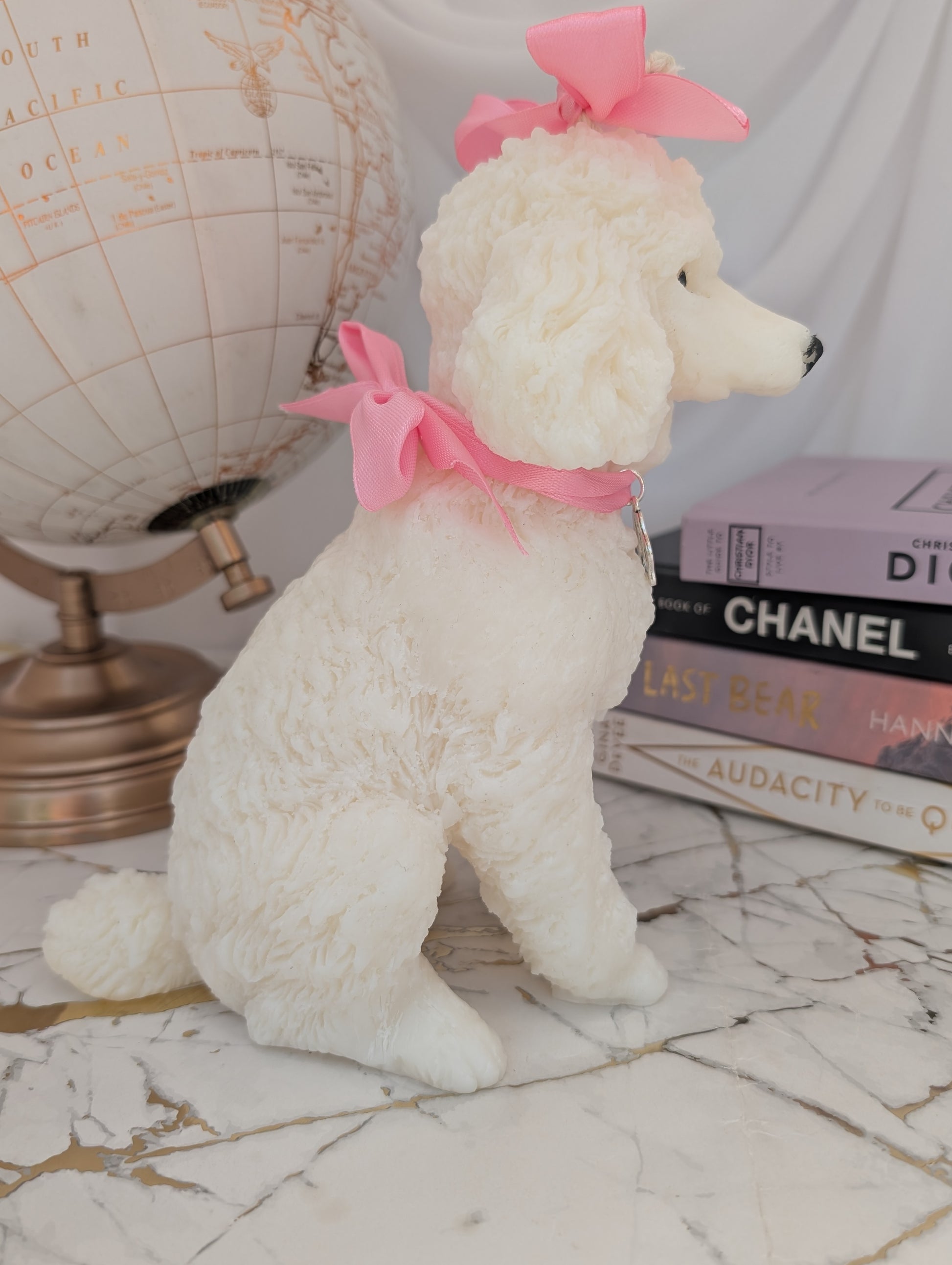 Right-side profile of handcrafted wax poodle candle showing lifelike expression, curled tail, and charm embellishments