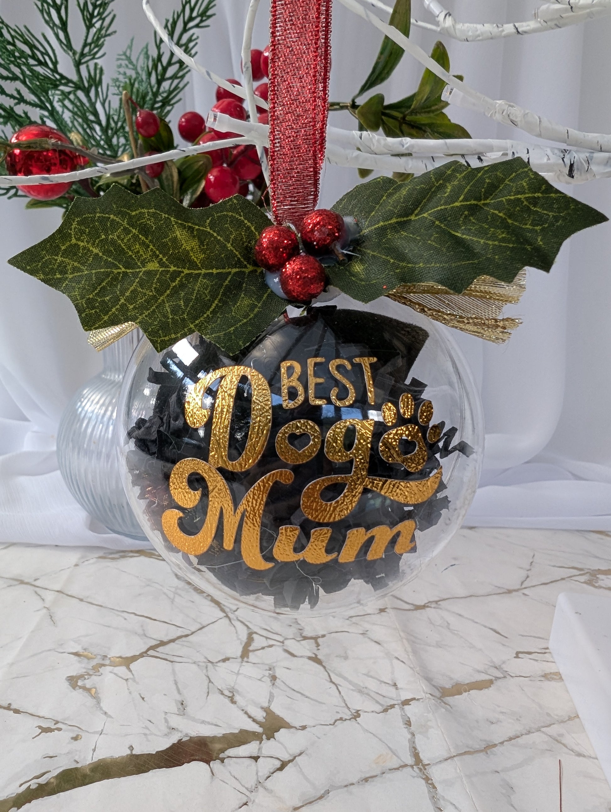 Christmas ornament with 'Best Dog Mum' text on a marble surface