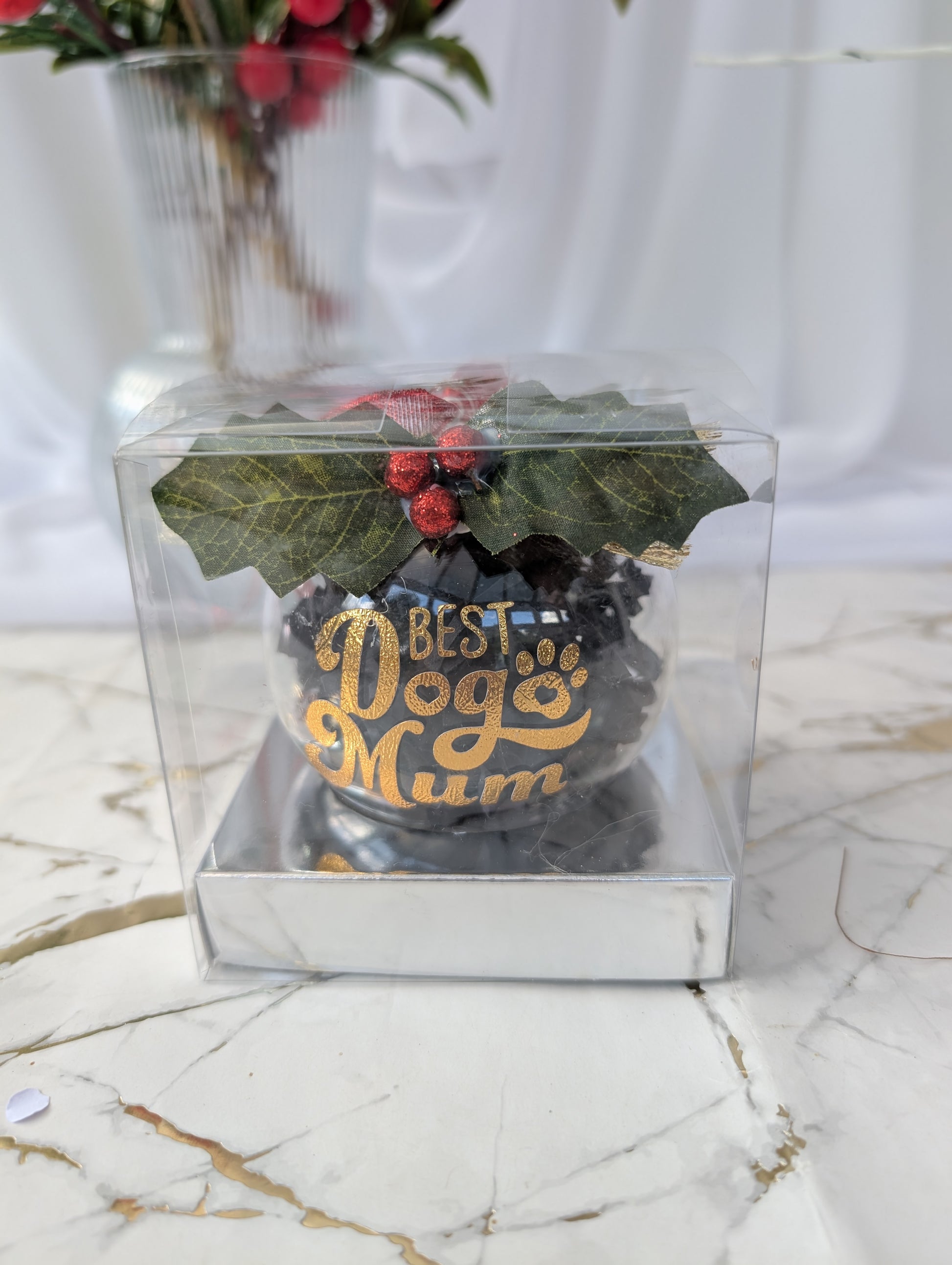 Decorative item with 'Best Dog Mum' text in a clear gift box on a marble surface.